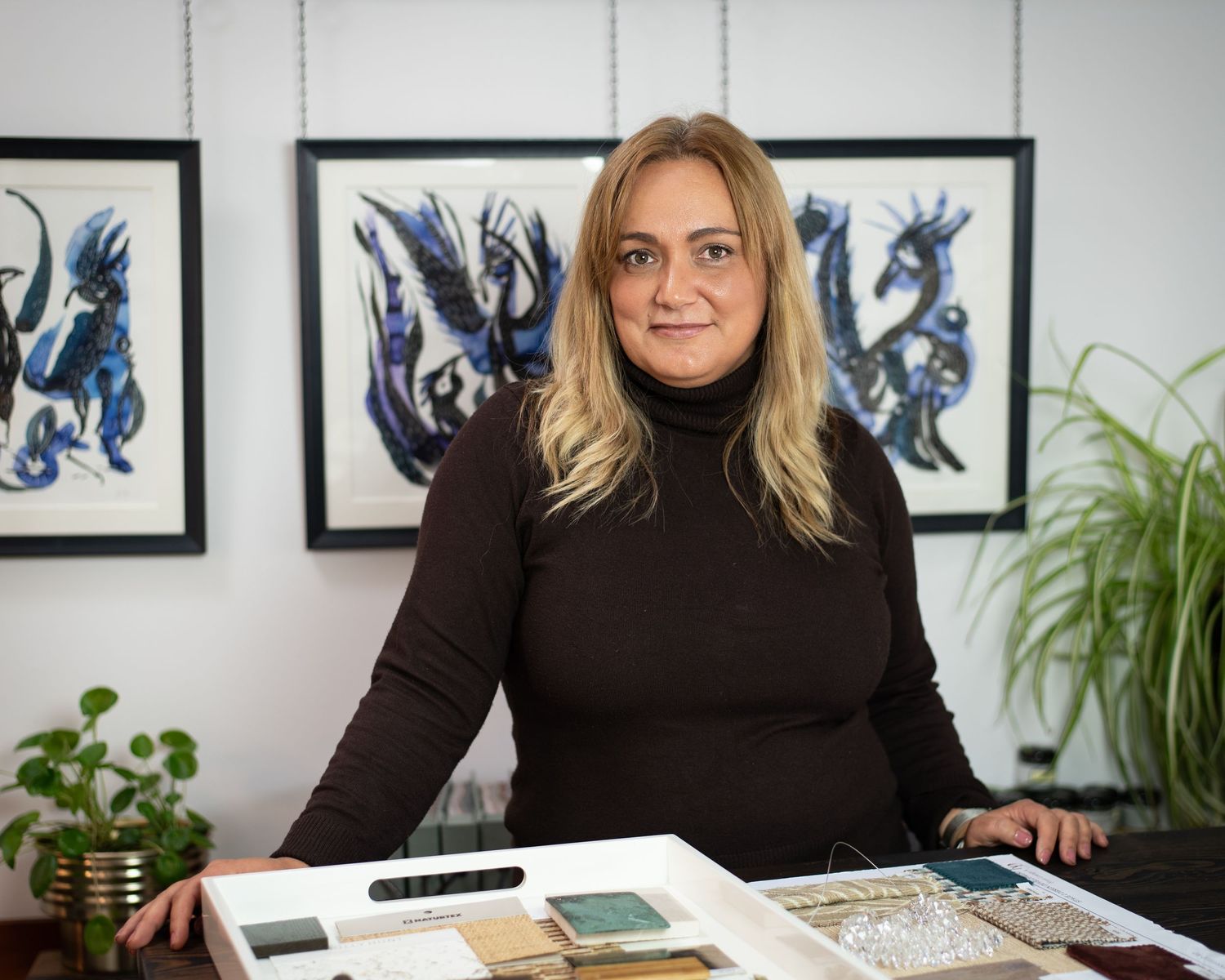 Katia Perez portrait image at her studio. Fran Aniorte art in the background.