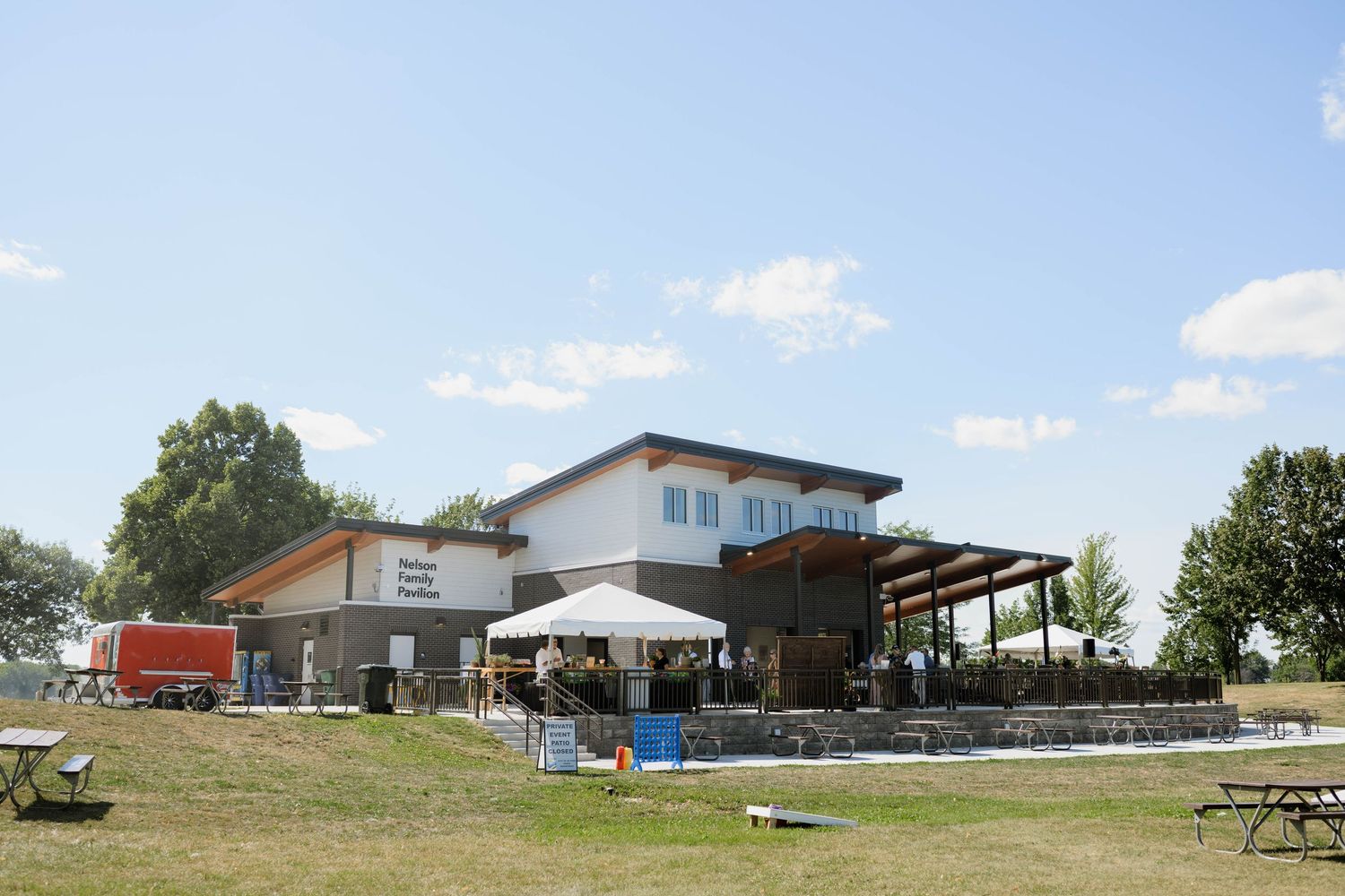 Modern wedding venue building with outdoor patio on sunny summer day.