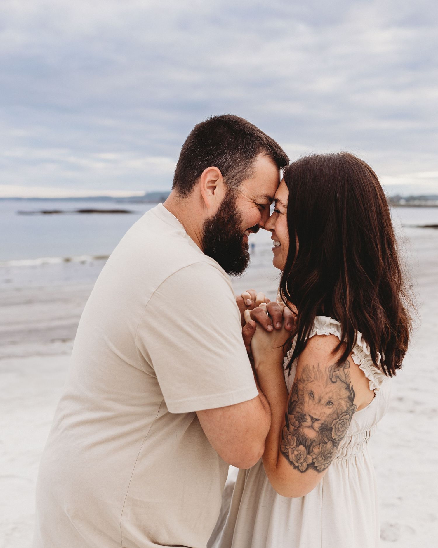 Professional photo of a couple smiling at each other on the beach