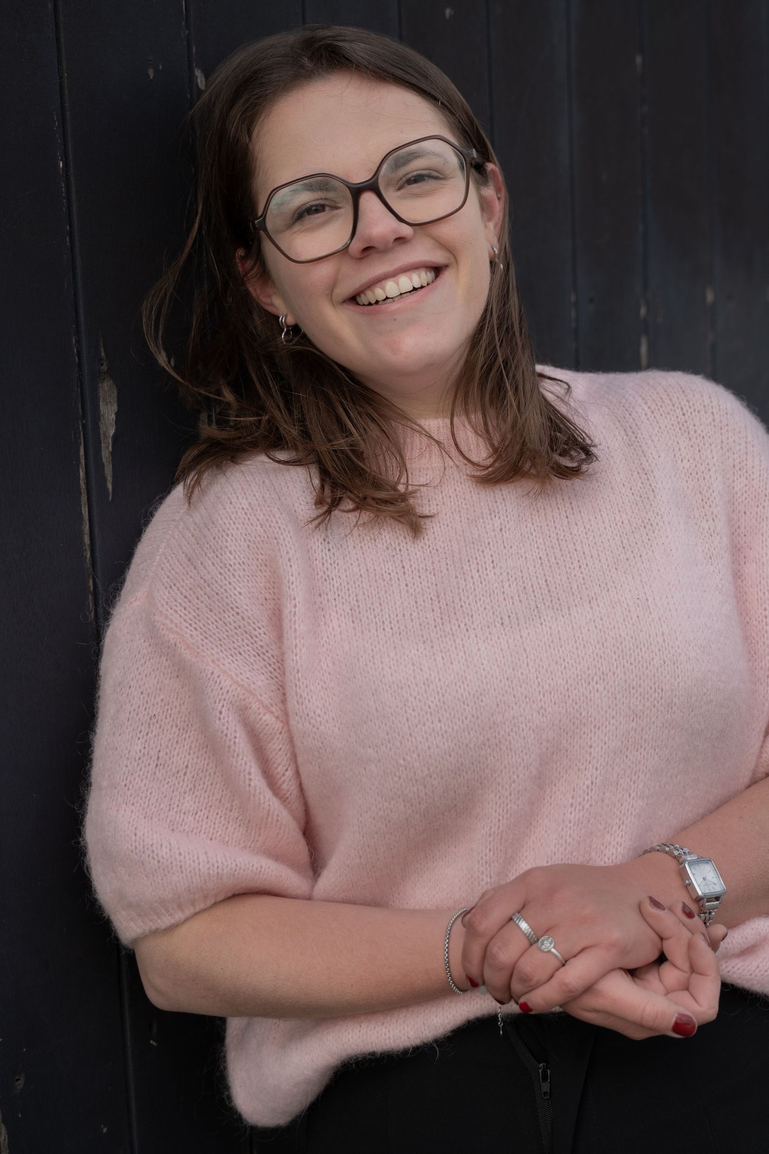 A soft pink sweater photographed against a dark background in multiple stylish poses.