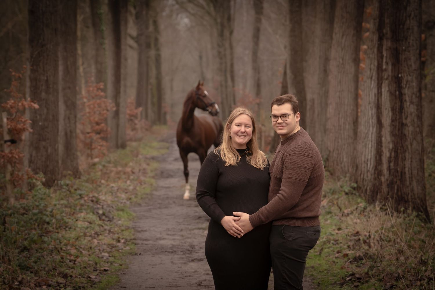 A couple shares an intimate moment together in a misty forest setting during an engagement photo session.