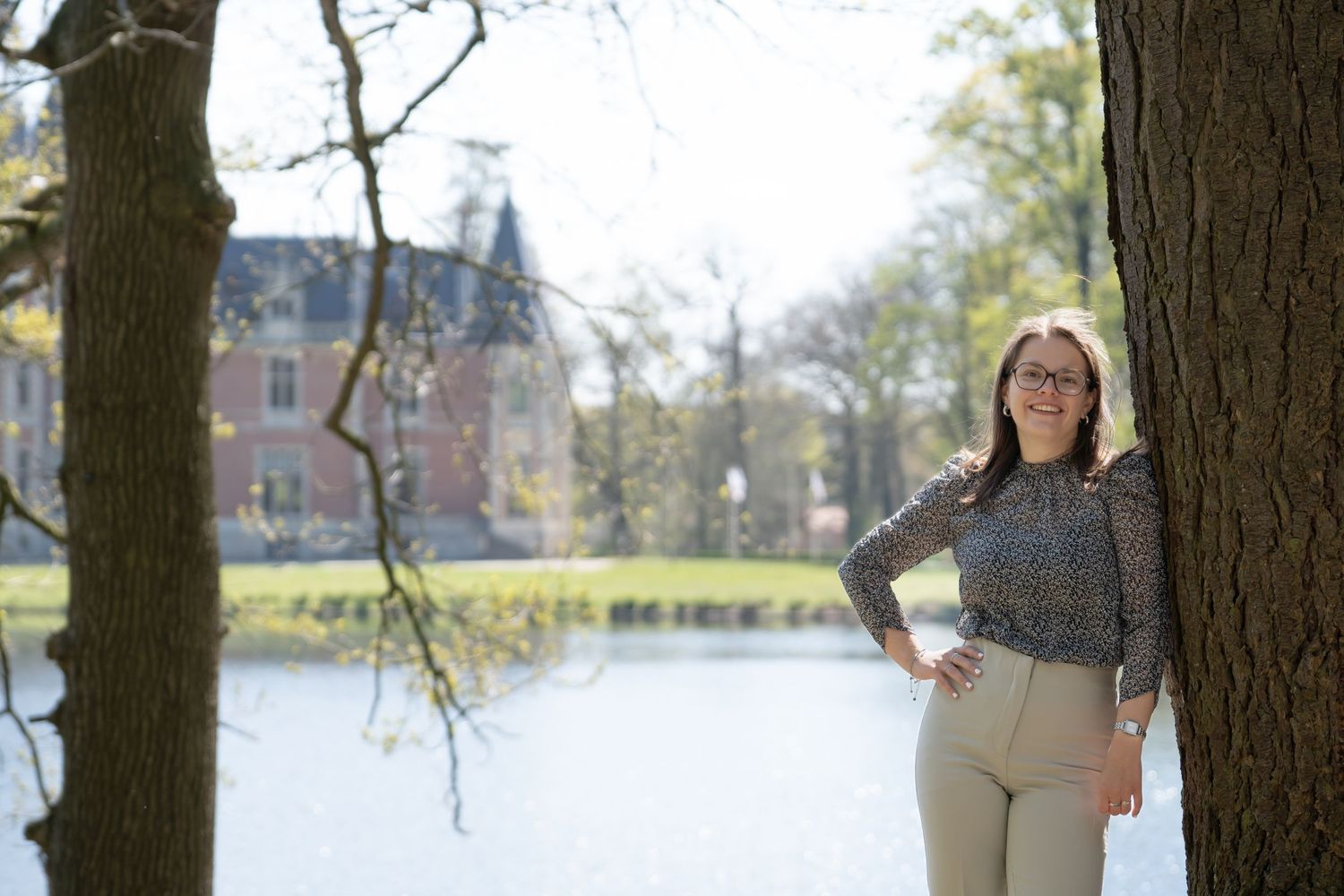 meisje poseert voor een meer met een kasteel op de achtergrond