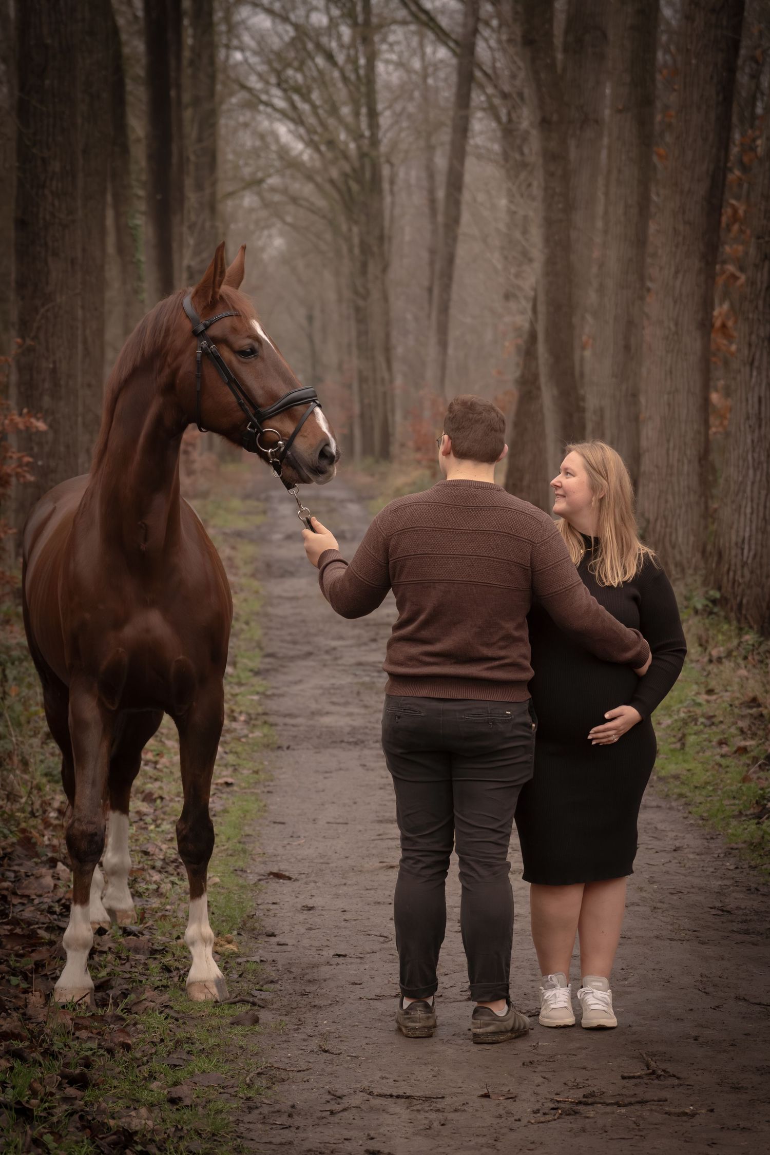 A couple walks with their brown horse down a misty forest path in a series of connected photos.