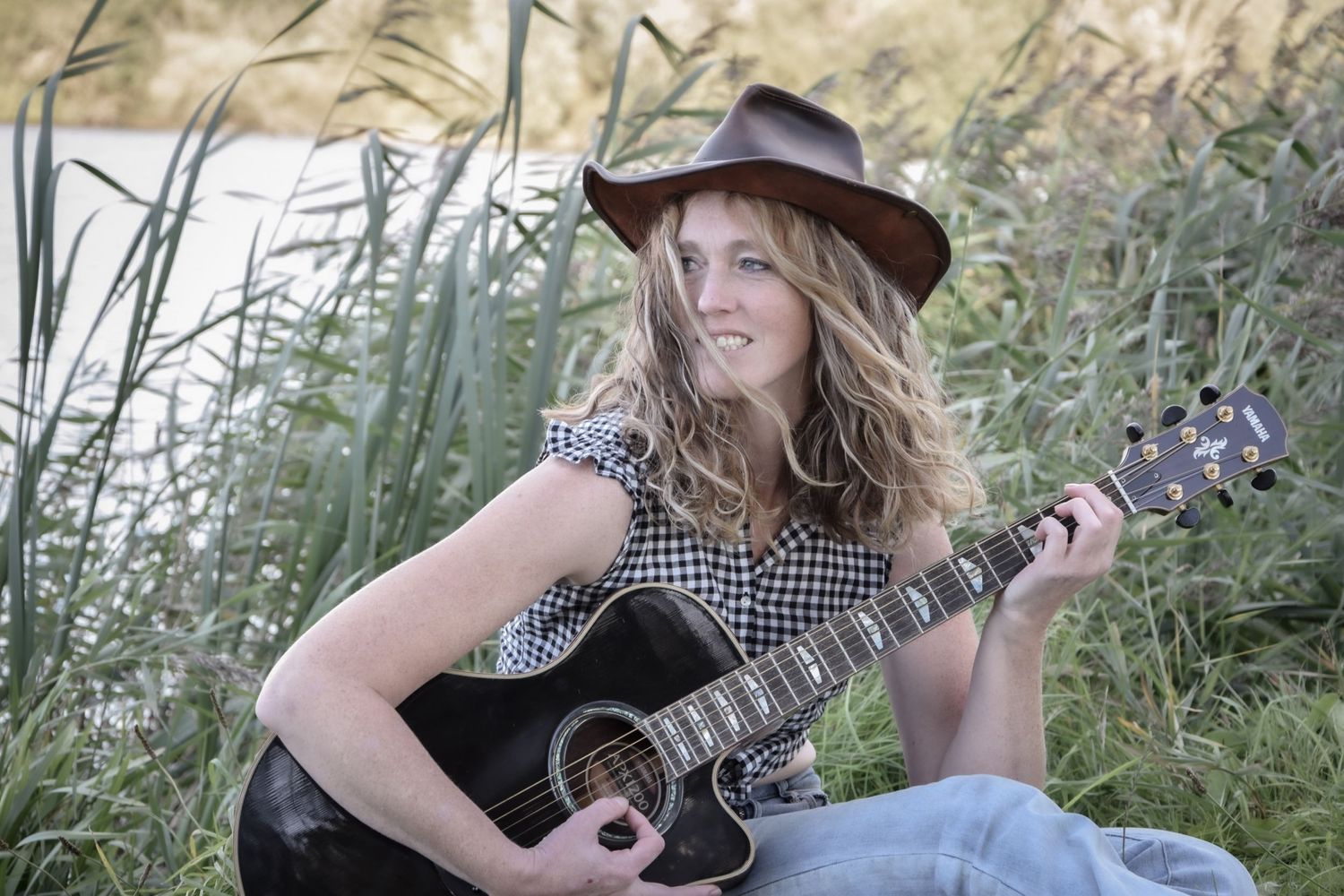 Casual outdoor photoshoot with guitar and western-inspired fashion.