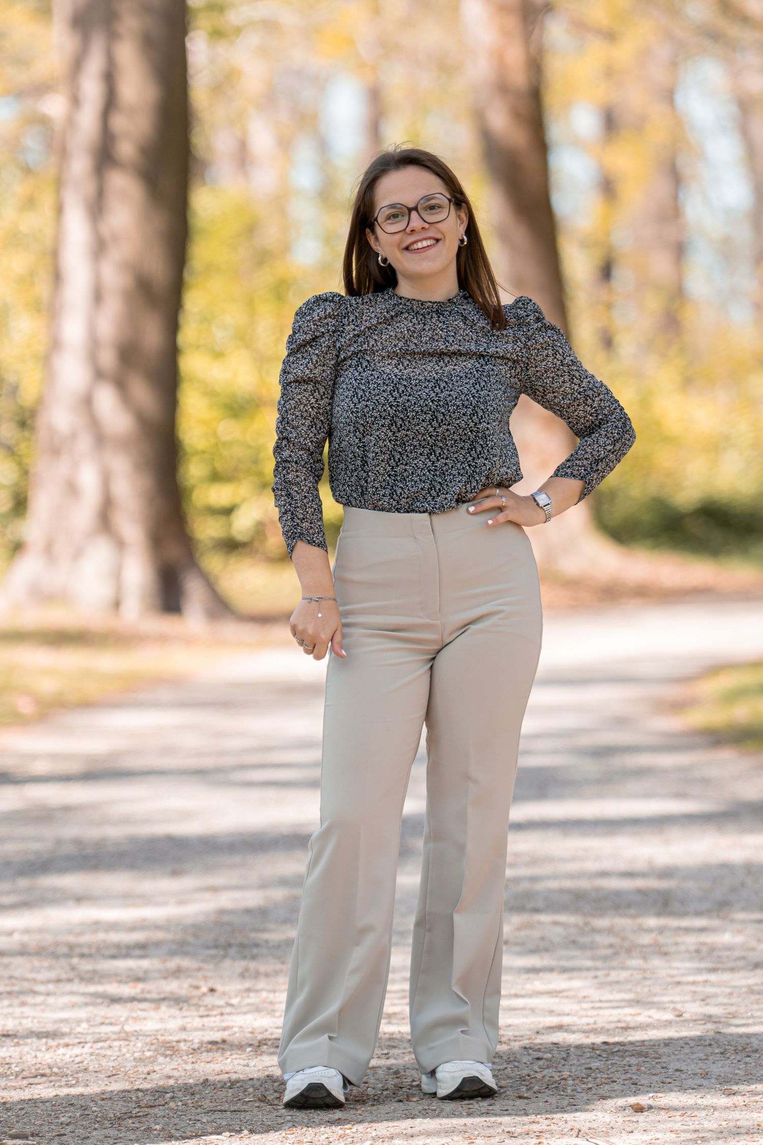 Portrait taken outdoors in autumn setting with natural golden light filtering through trees.