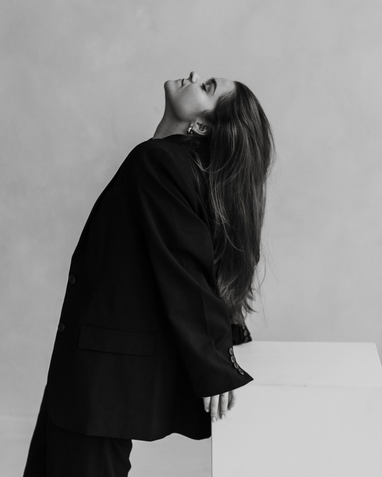 Artistic black and white portrait of person with head tilted back dramatically.
