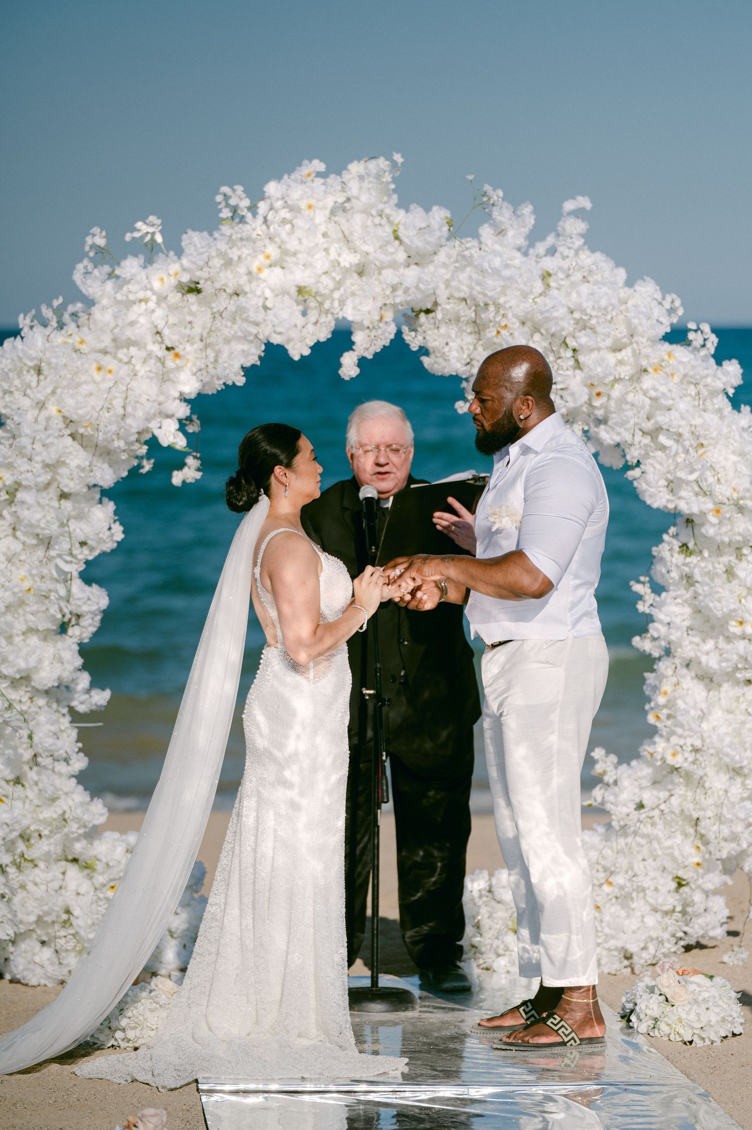 A beachside wedding ceremony with white floral arrangements. - - Chicago's Western Suburbs Wedding
