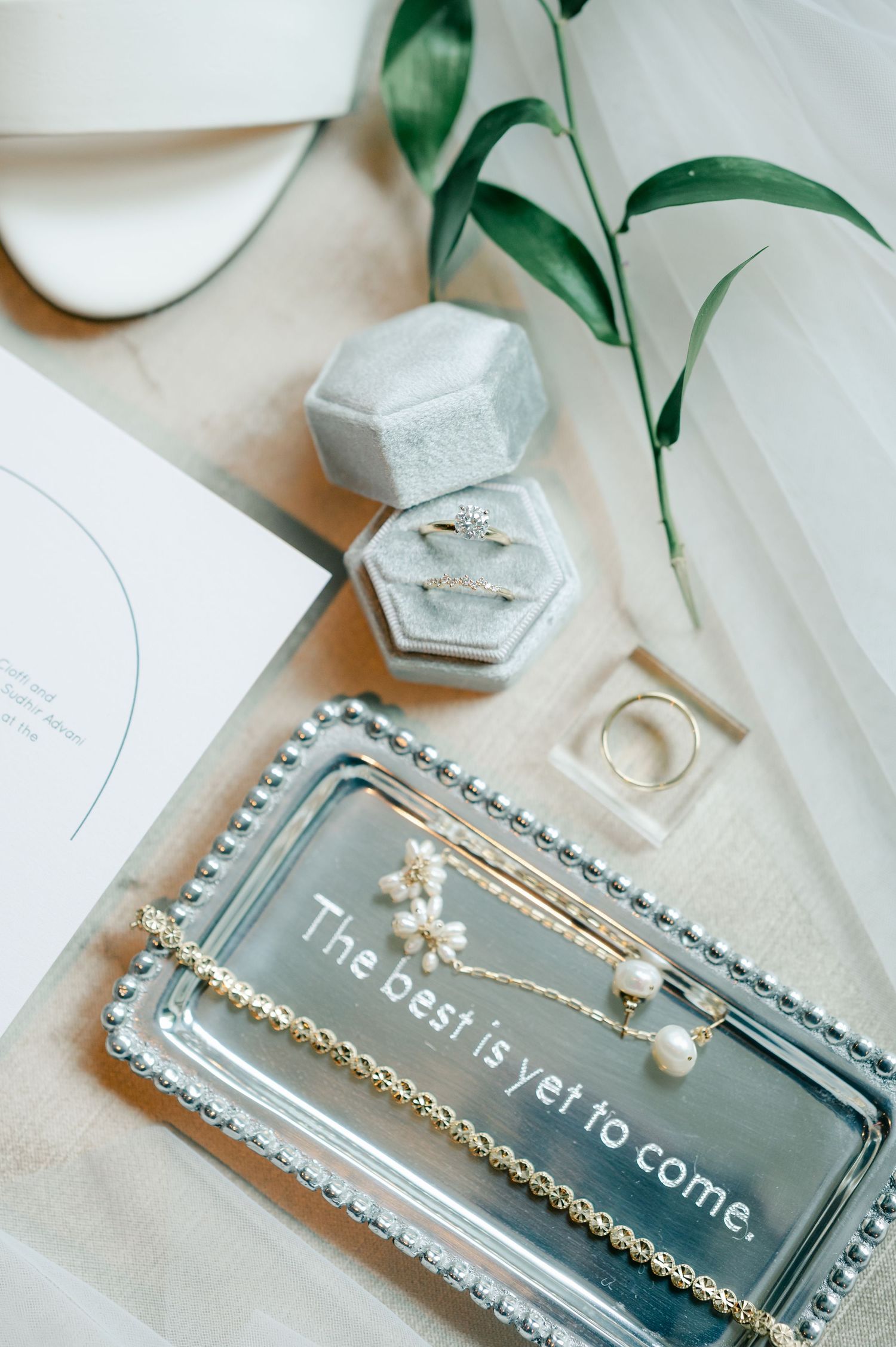 Elegant flatlay of clear glass perfume bottle with gold chain and pearl jewelry on white surface. - Hyatt Lodge Oak Brook
