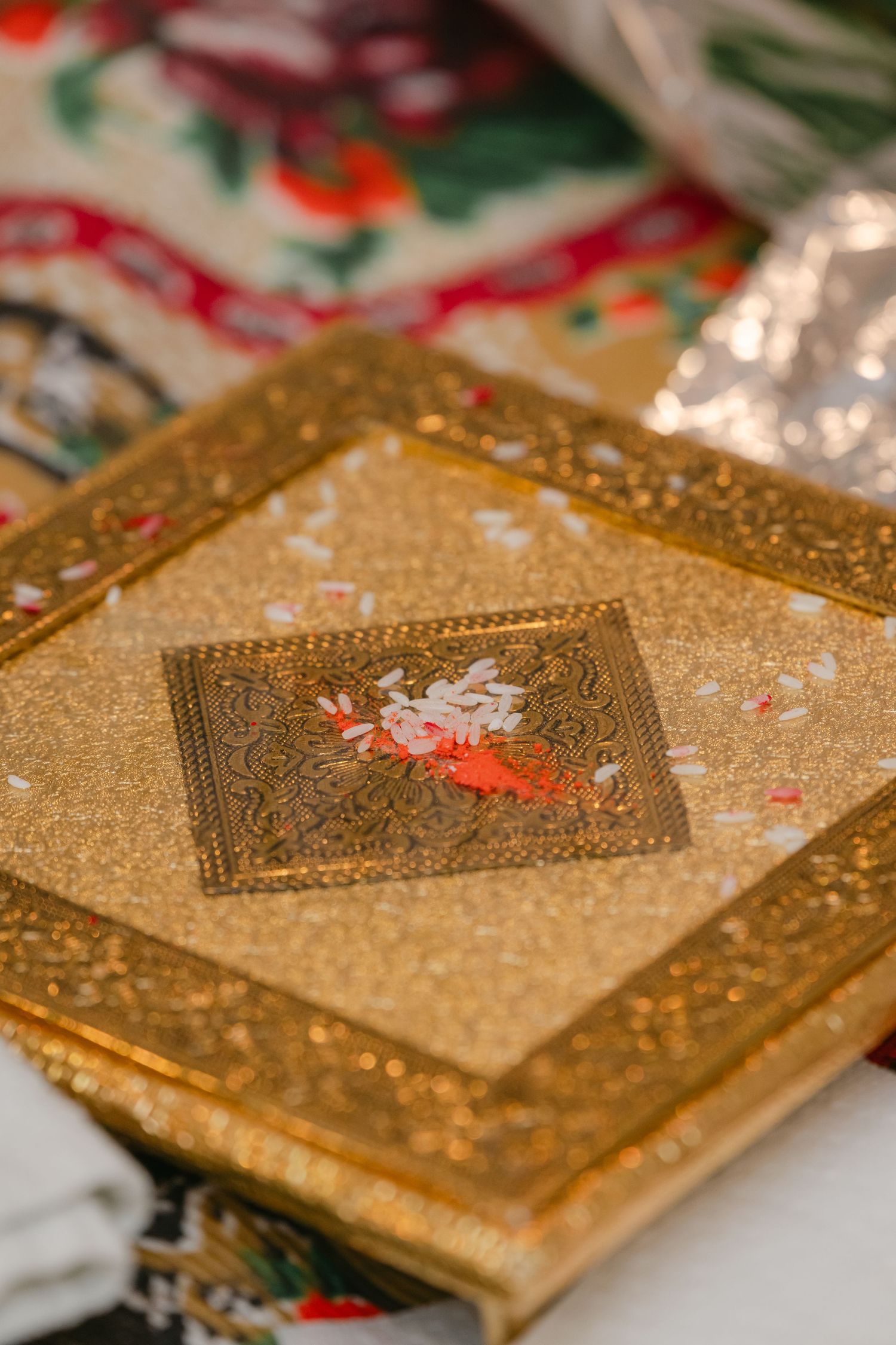 The Brix on the Fox Wedding - Ornate golden wedding invitation cards with intricate designs and patterns laid out in a row.
