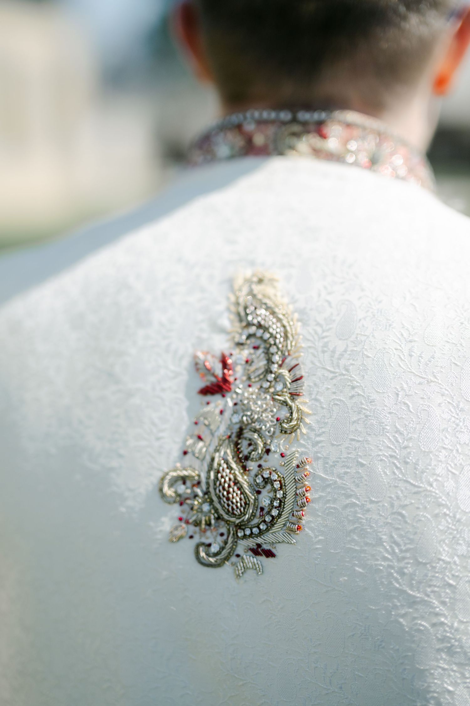 The Brix on the Fox Wedding - A macro sequence showing a tiny silver and red spider brooch on a textured white surface.
