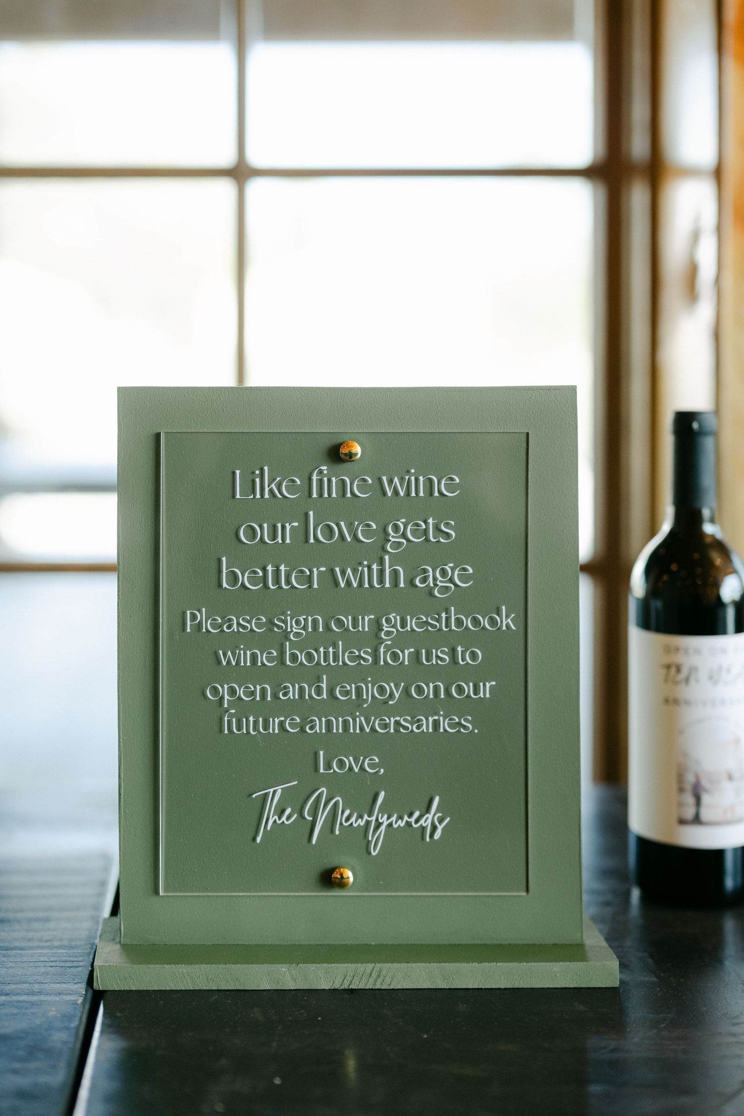 Green wedding sign with a guestbook wine bottle request from The Newlyweds. - Youngblood Vineyard Wedding