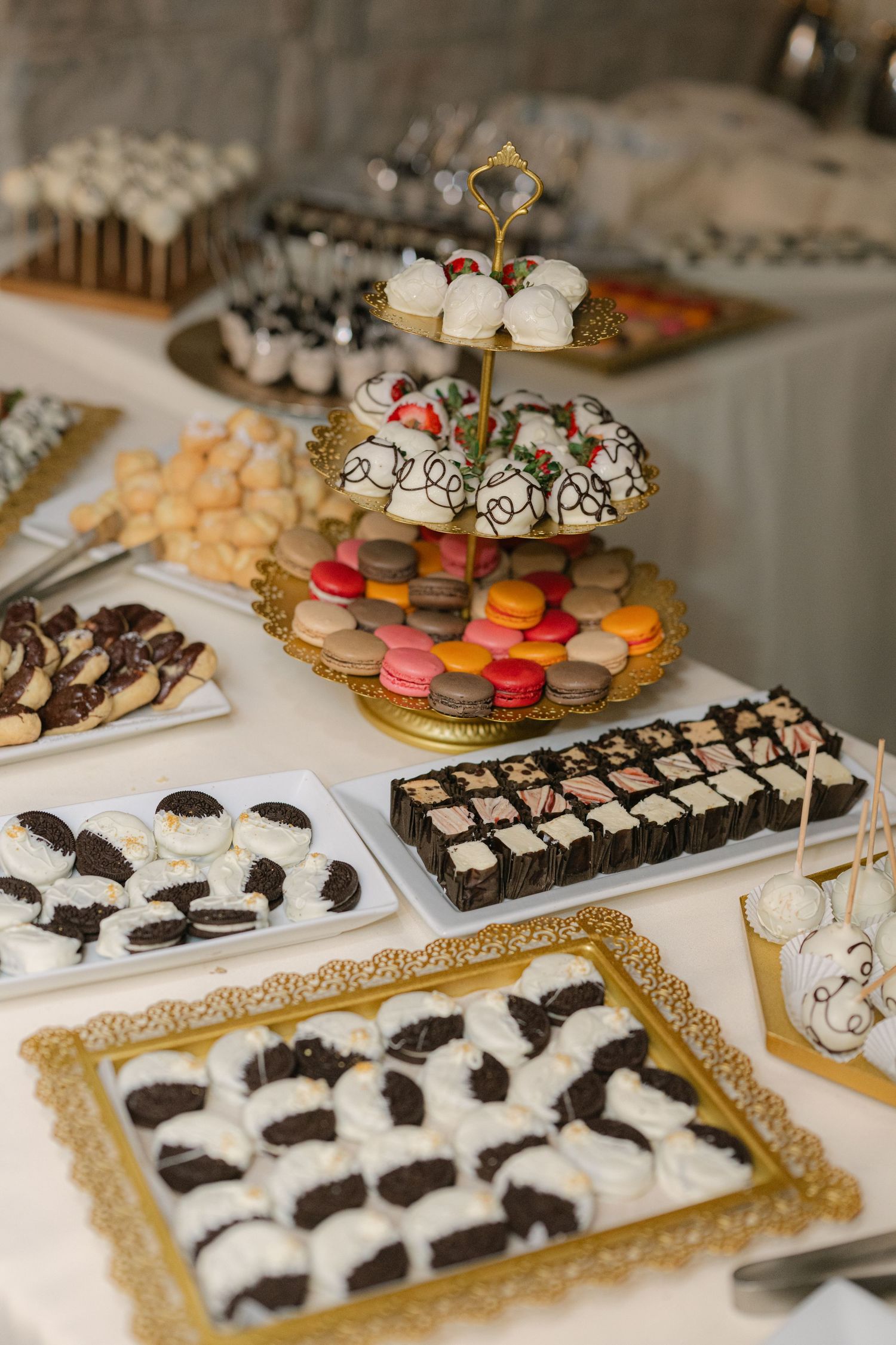 Elegant dessert display featuring colorful macarons, chocolate-dipped cookies. - Meyer's Castle Events