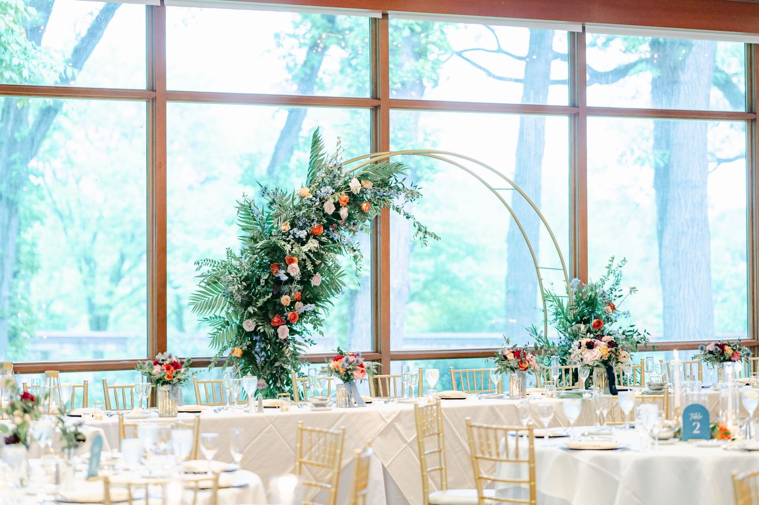 Elegant wedding reception venue with panoramic windows, white tablecloths, and floral centerpieces. - Hyatt Lodge Oak Brook