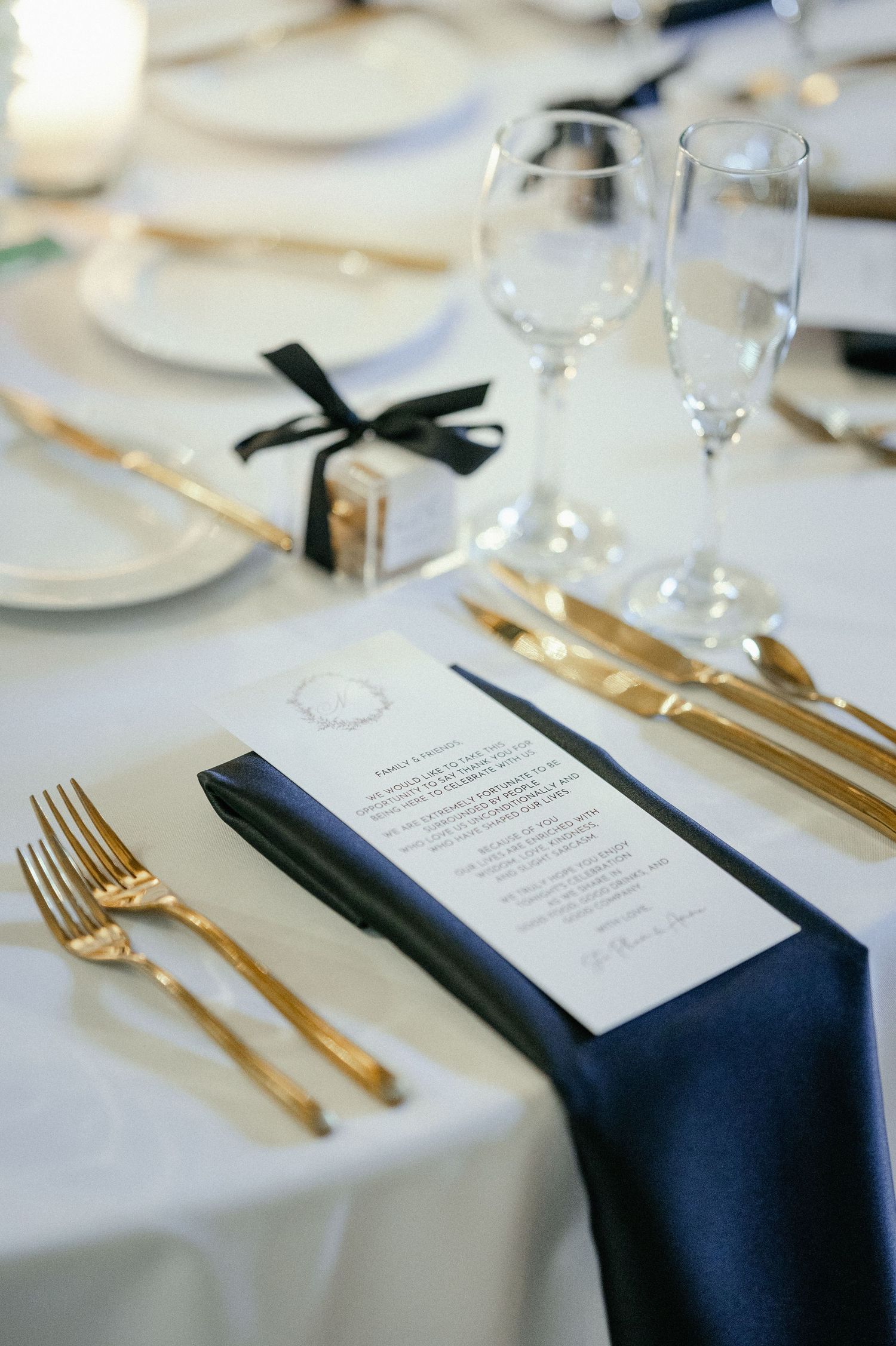 Elegant wedding table setting with gold flatware, navy napkin, menu card, and champagne glasses. - The Armour House in Lake Forest