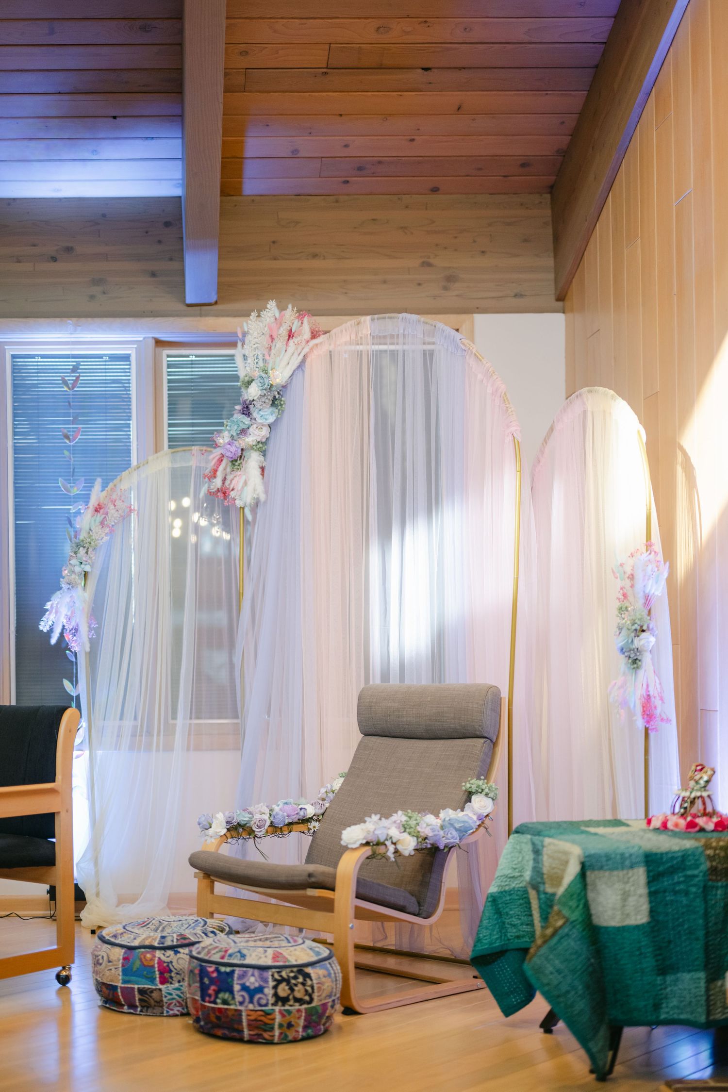 The Brix on the Fox Wedding - Cozy reading nook with hanging white canopy and green blanket in wooden interior with natural lighting.