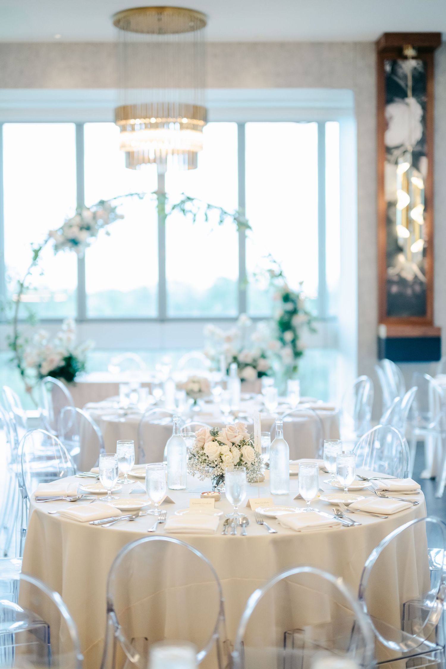 Elegant wedding reception venue with round tables draped in white linens and floral centerpieces. - LM Studio Chicago Wedding