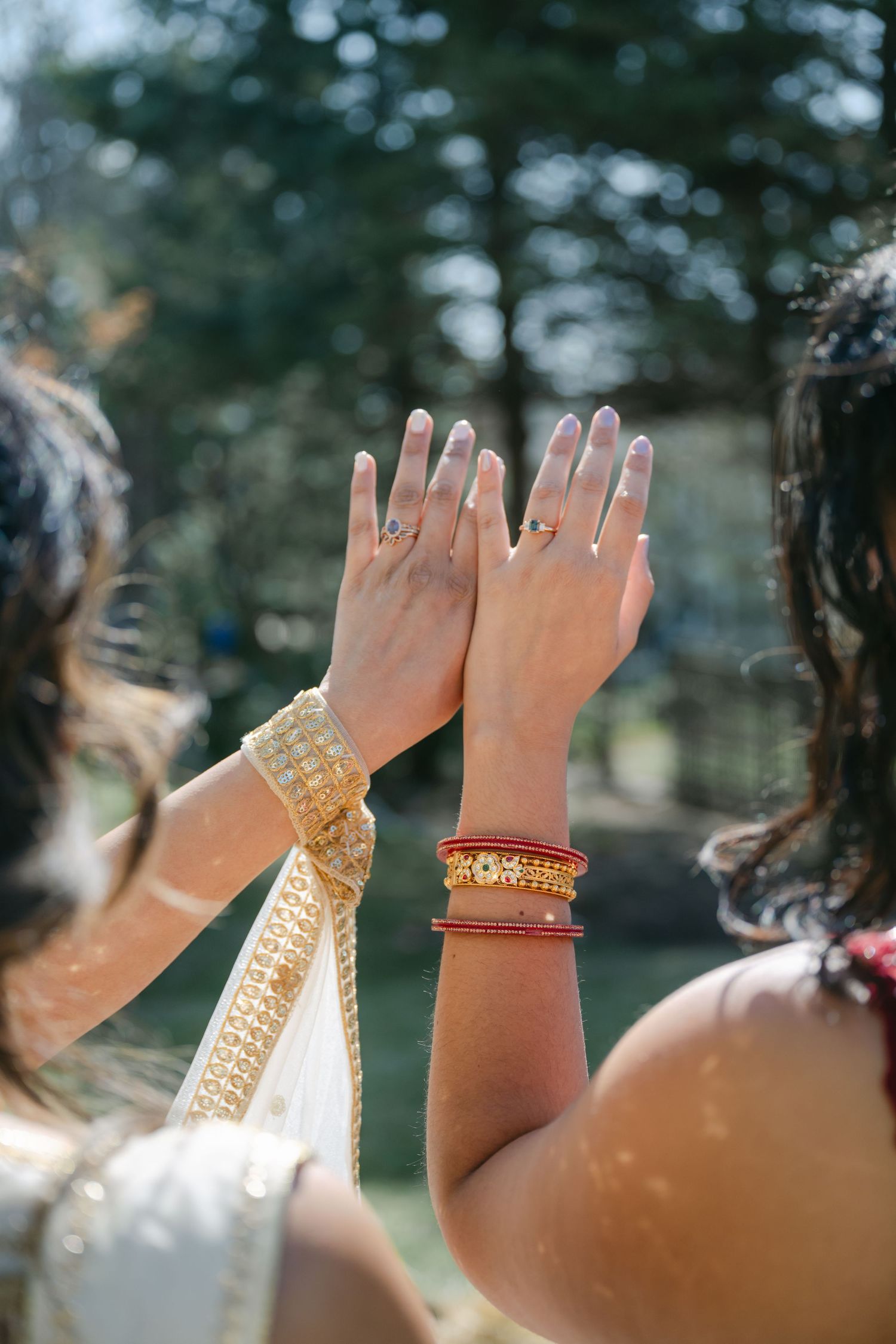 The Brix on the Fox Wedding - Multiple hands raised showing traditional Indian bridal bangles and jewelry.