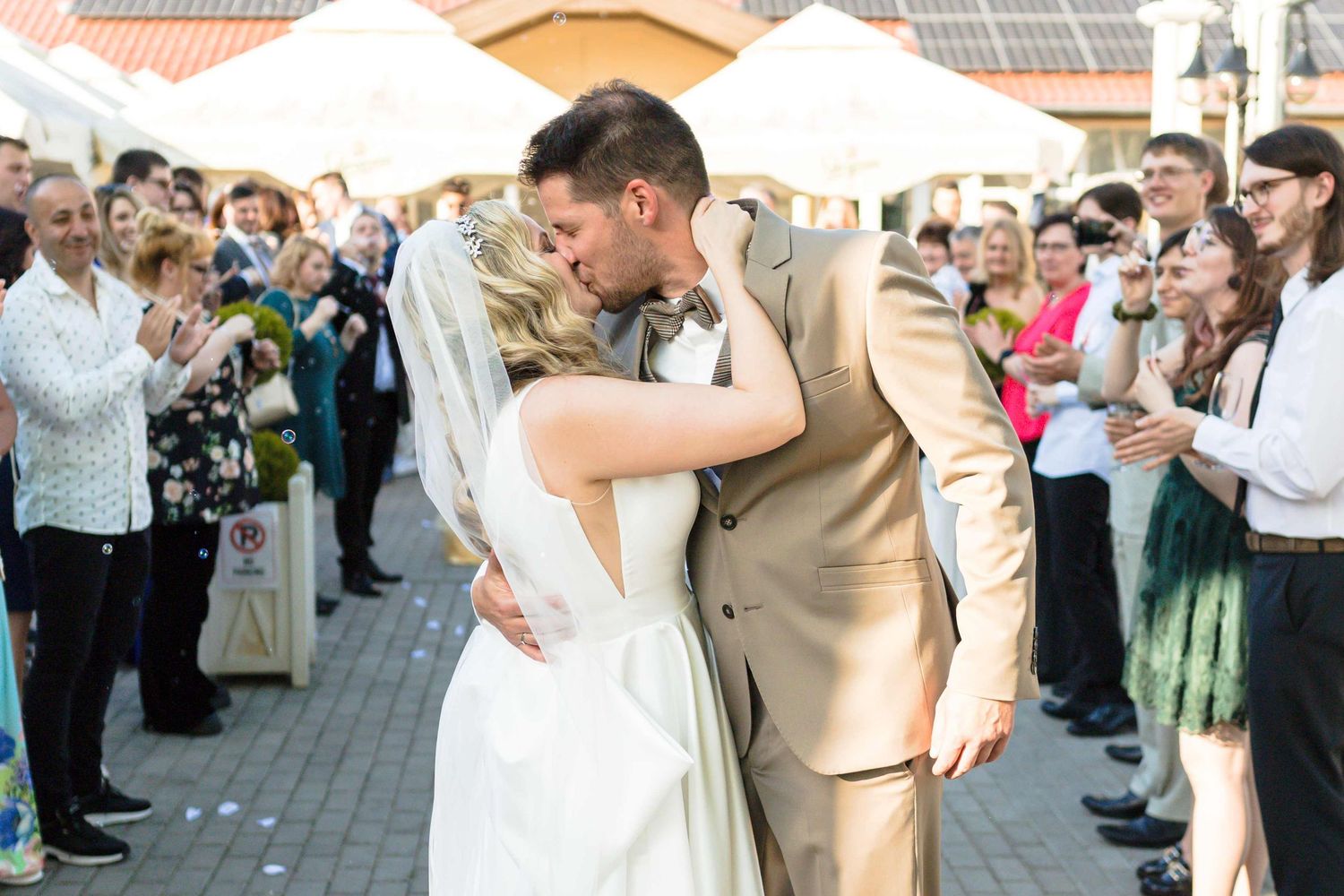 A joyful couple shares their first dance as newlyweds while wedding guests look on and take photos.