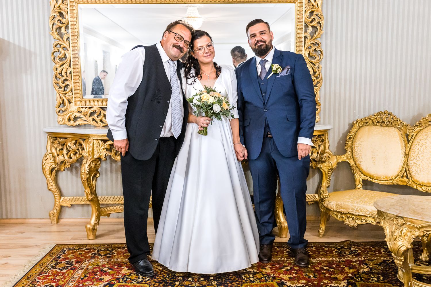 Elegant wedding venue with ornate gold-framed mirrors and classic white decor.