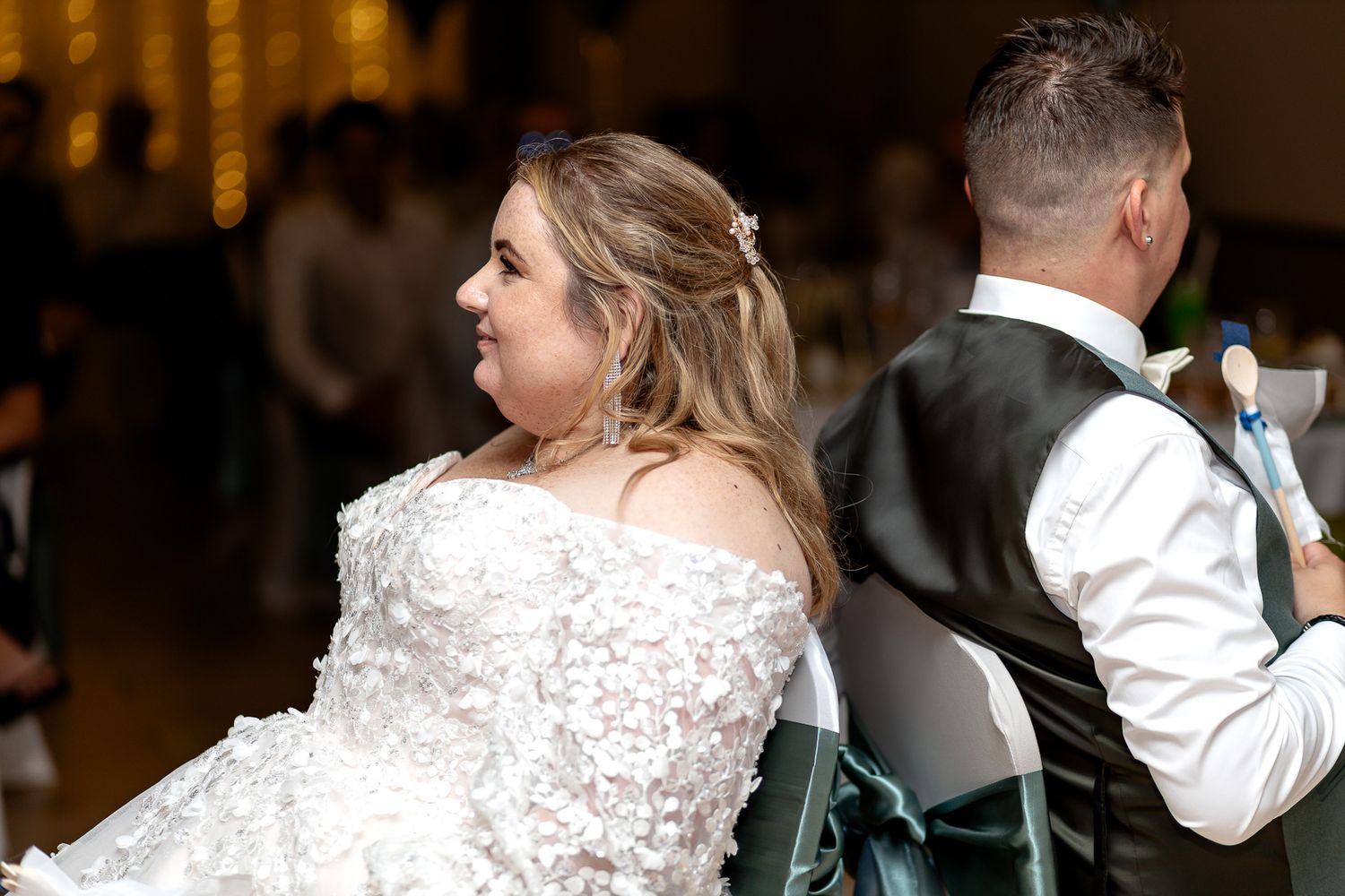 A couple dances together at an elegant indoor wedding reception venue with warm lighting.
