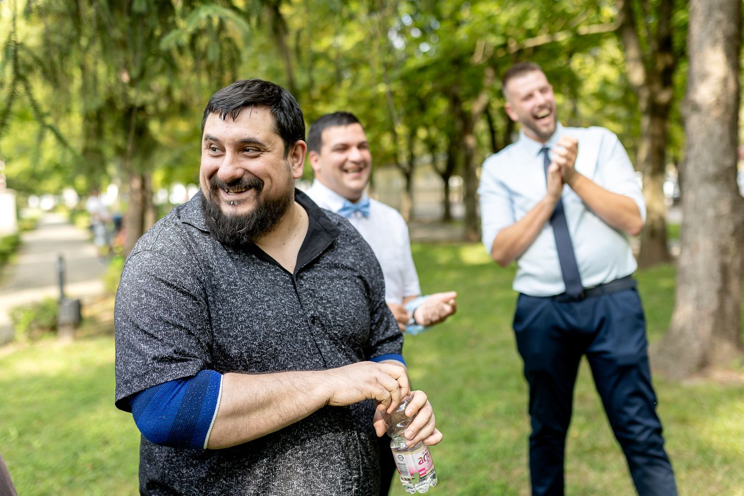 A series of candid wedding party photos showing joyful moments and laughter in a park setting.