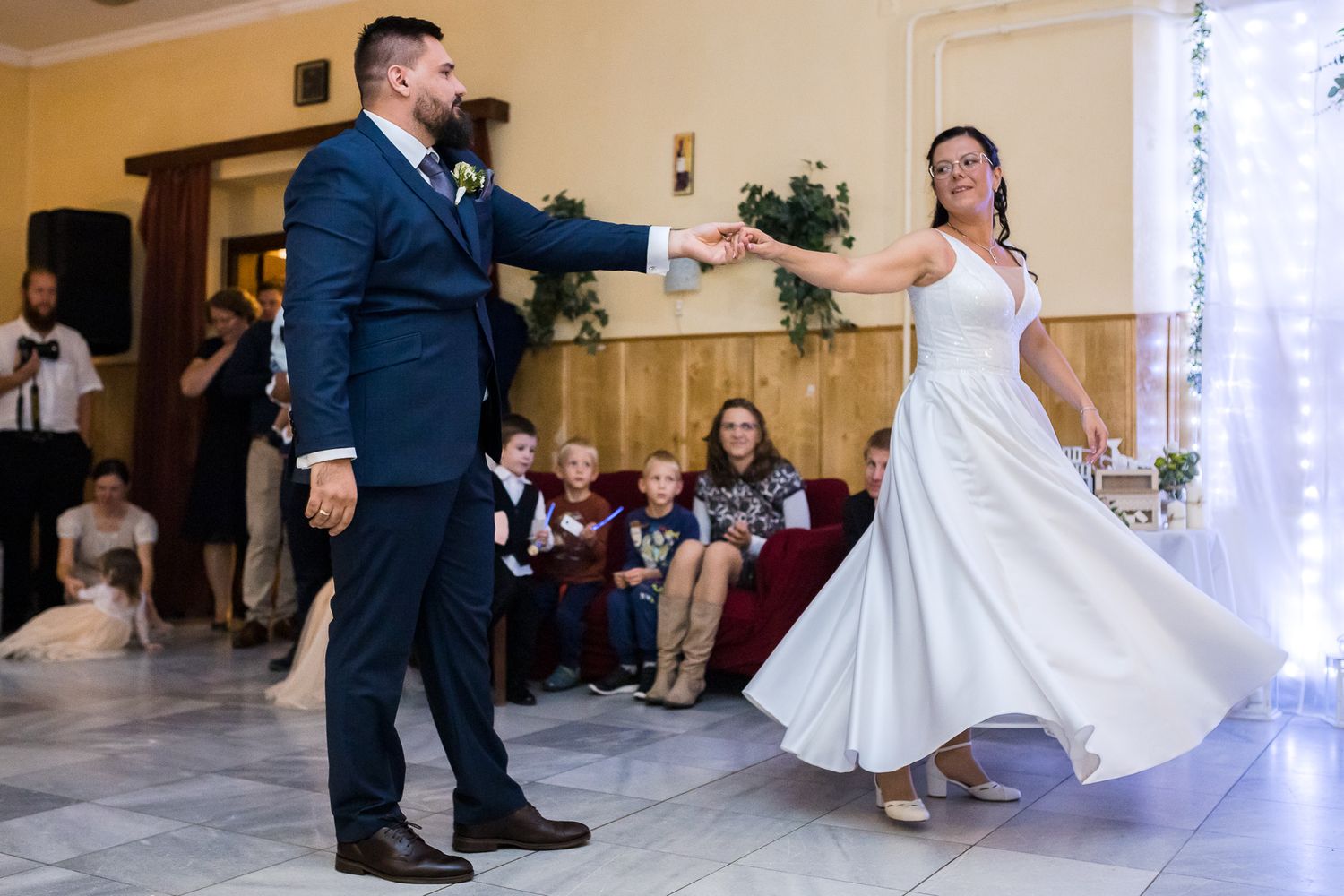 A couple performs a wedding dance move where the bride's white dress swirls gracefully across the dance floor.