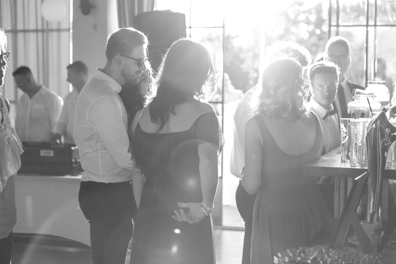 Wedding guests dancing and celebrating at indoor reception.