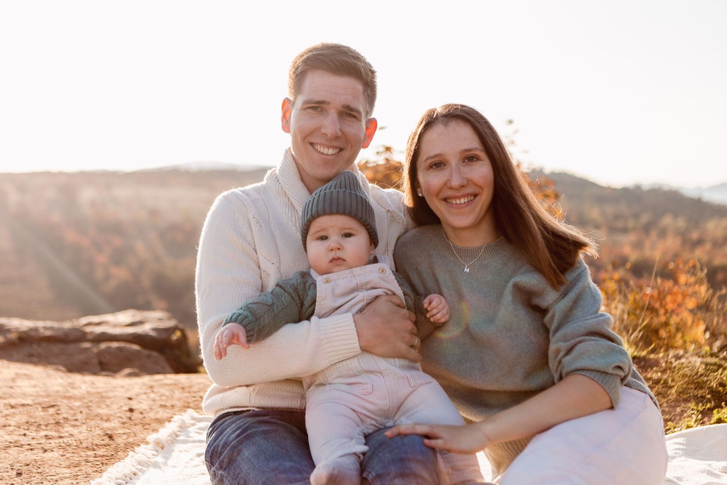 Sweet family moment captured in soft natural lighting against mountain backdrop.