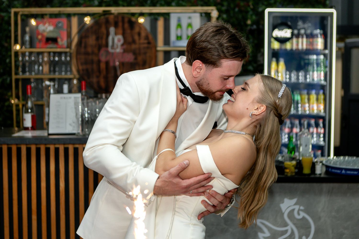 Couple sharing an intimate moment near wedding cakes at their reception.