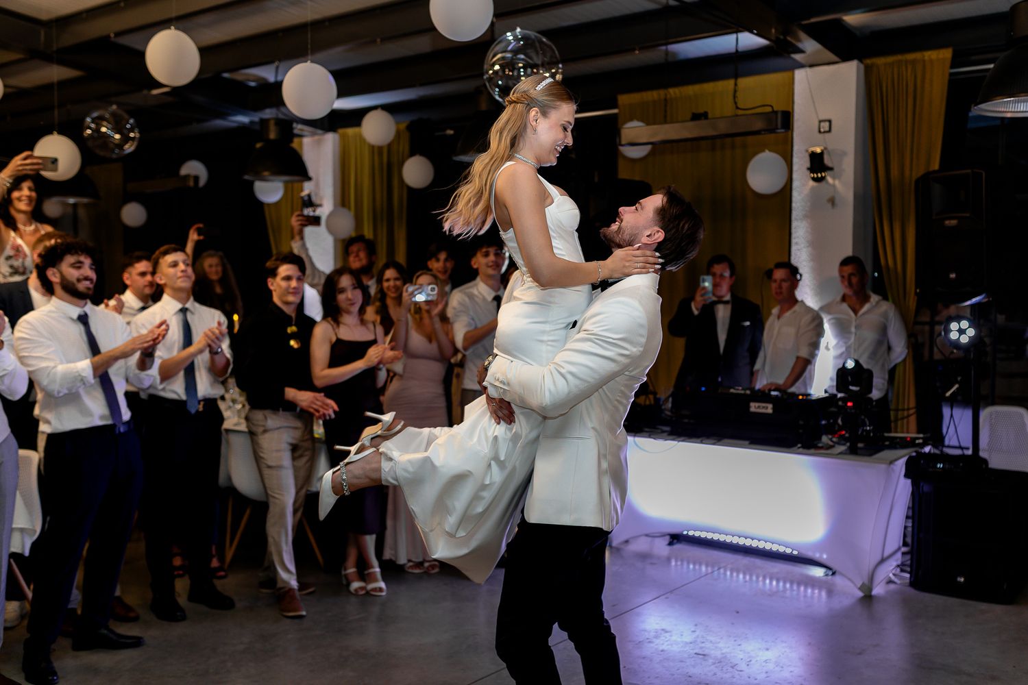 Wedding couple executes an impressive dance lift during their reception celebration.