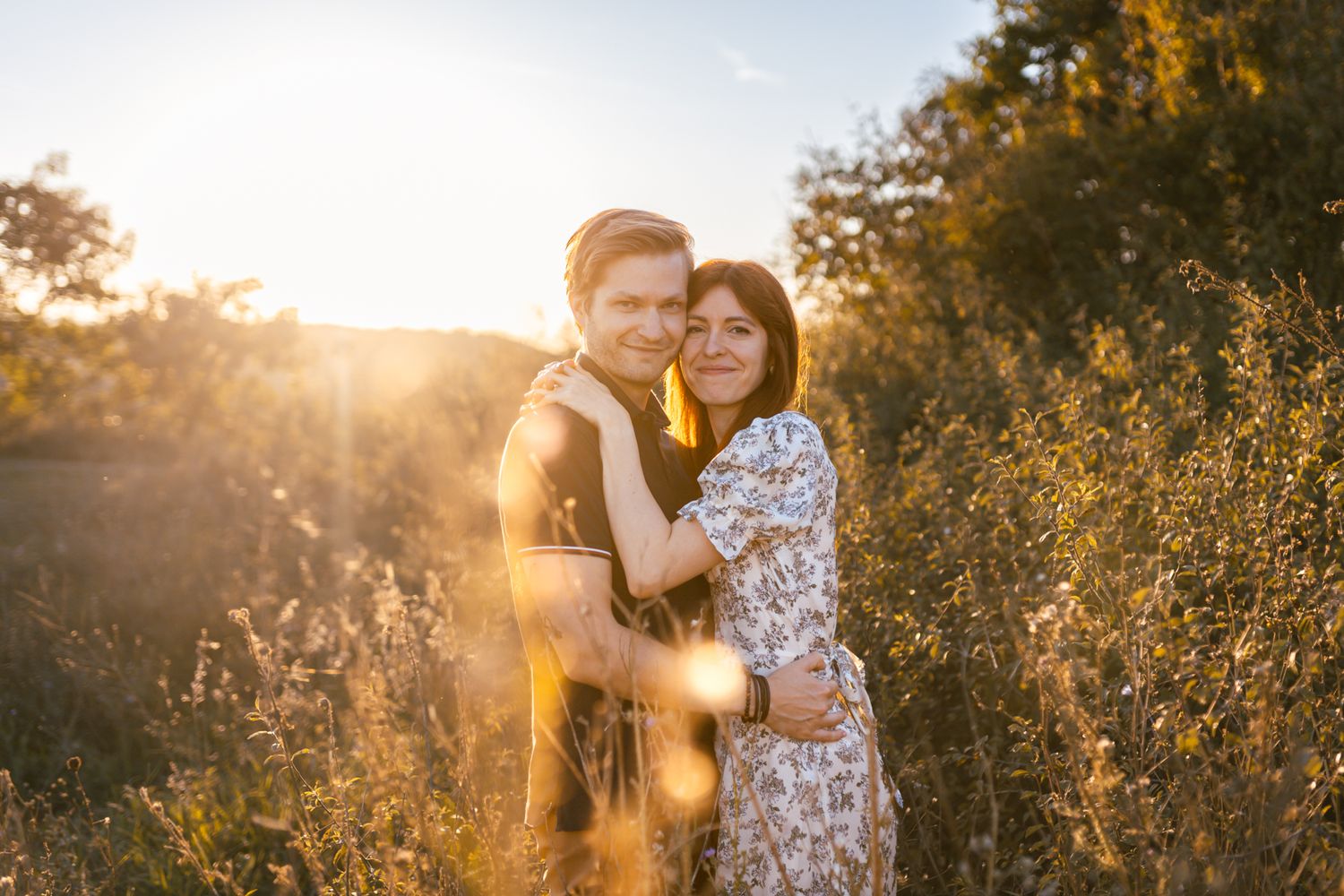 Golden sunset light illuminates a couple during their romantic outdoor engagement session.