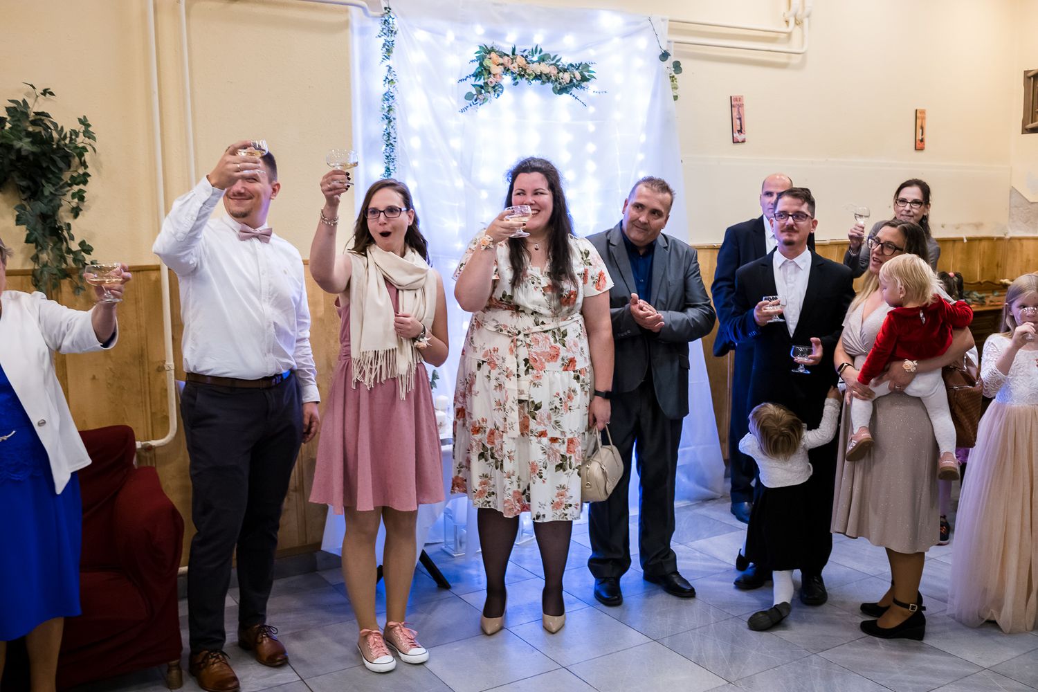 Wedding guests form a line dance on a decorated dance floor during the reception celebration.