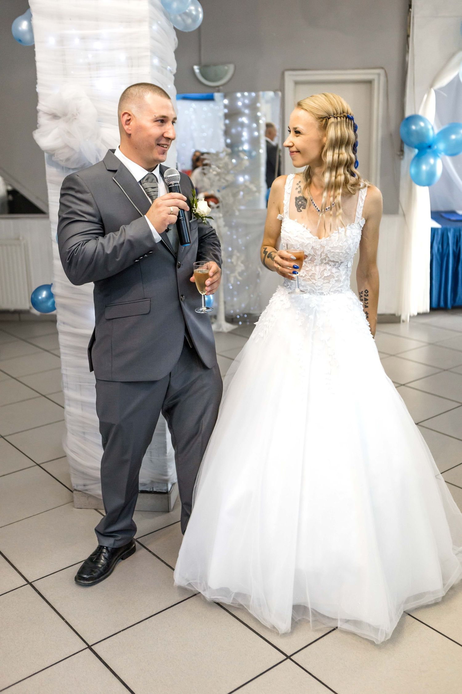 A couple shares a tender moment during their first dance at their wedding reception in a bright indoor venue.