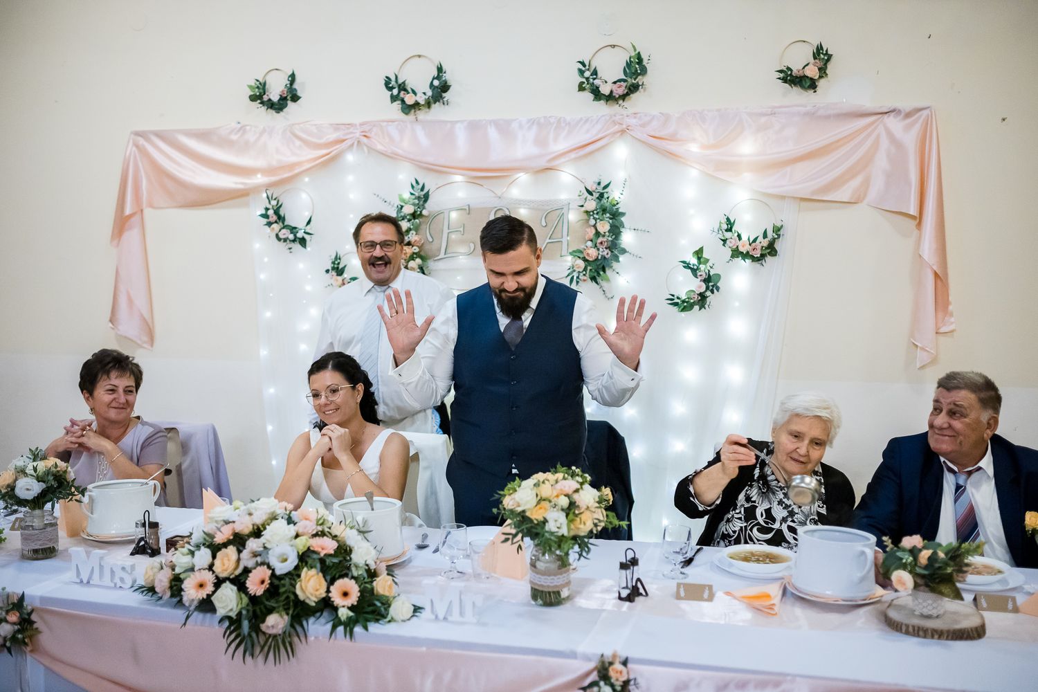 Wedding reception table decorated with pink and white accents and floral centerpieces at an elegant indoor venue.