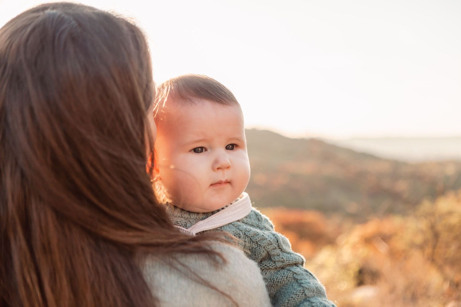 Candid family moments photographed during golden hour with mountains in the background.