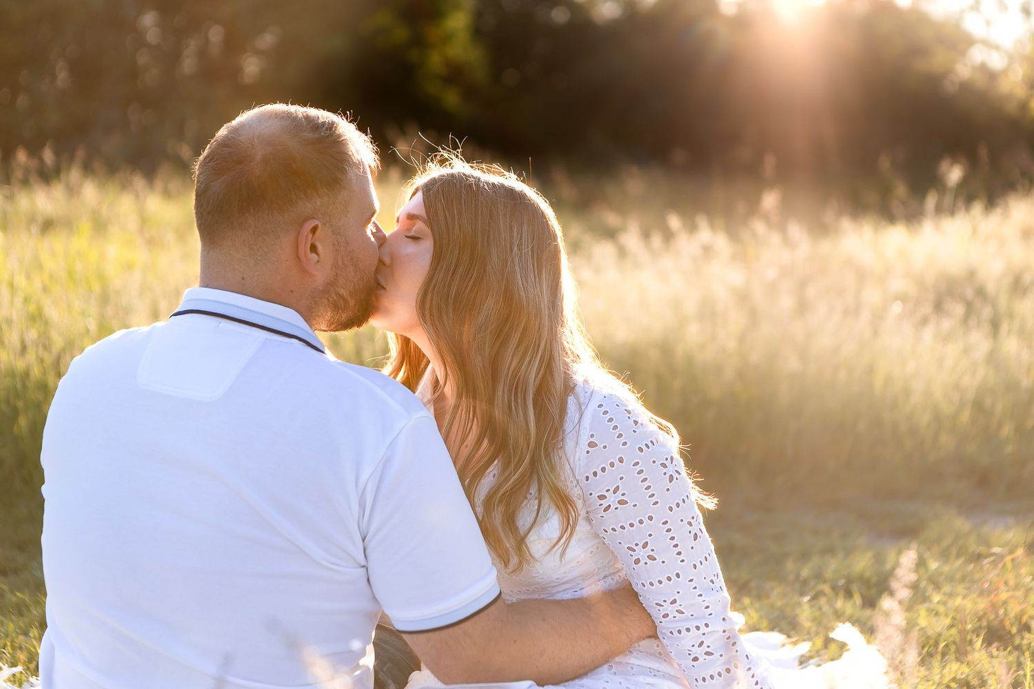 Golden sunlight bathes couple in warm glow during mountain photoshoot.