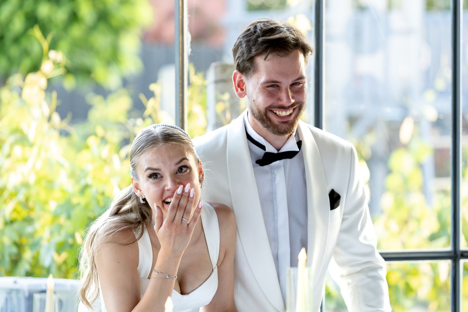 Wedding guests share joyful moments during an elegant indoor celebration.