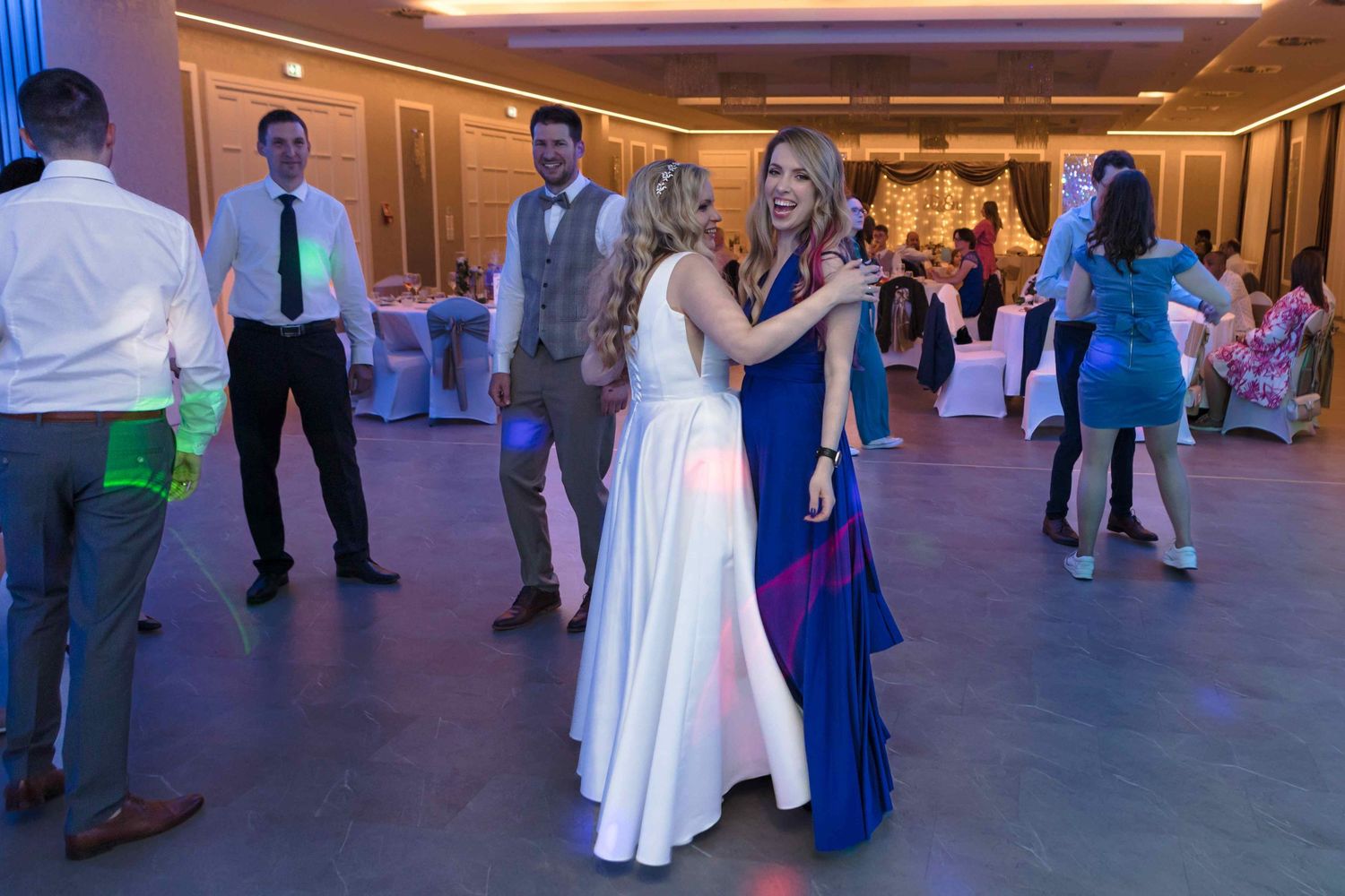 Couples dancing together on a spacious ballroom floor during an elegant evening event.