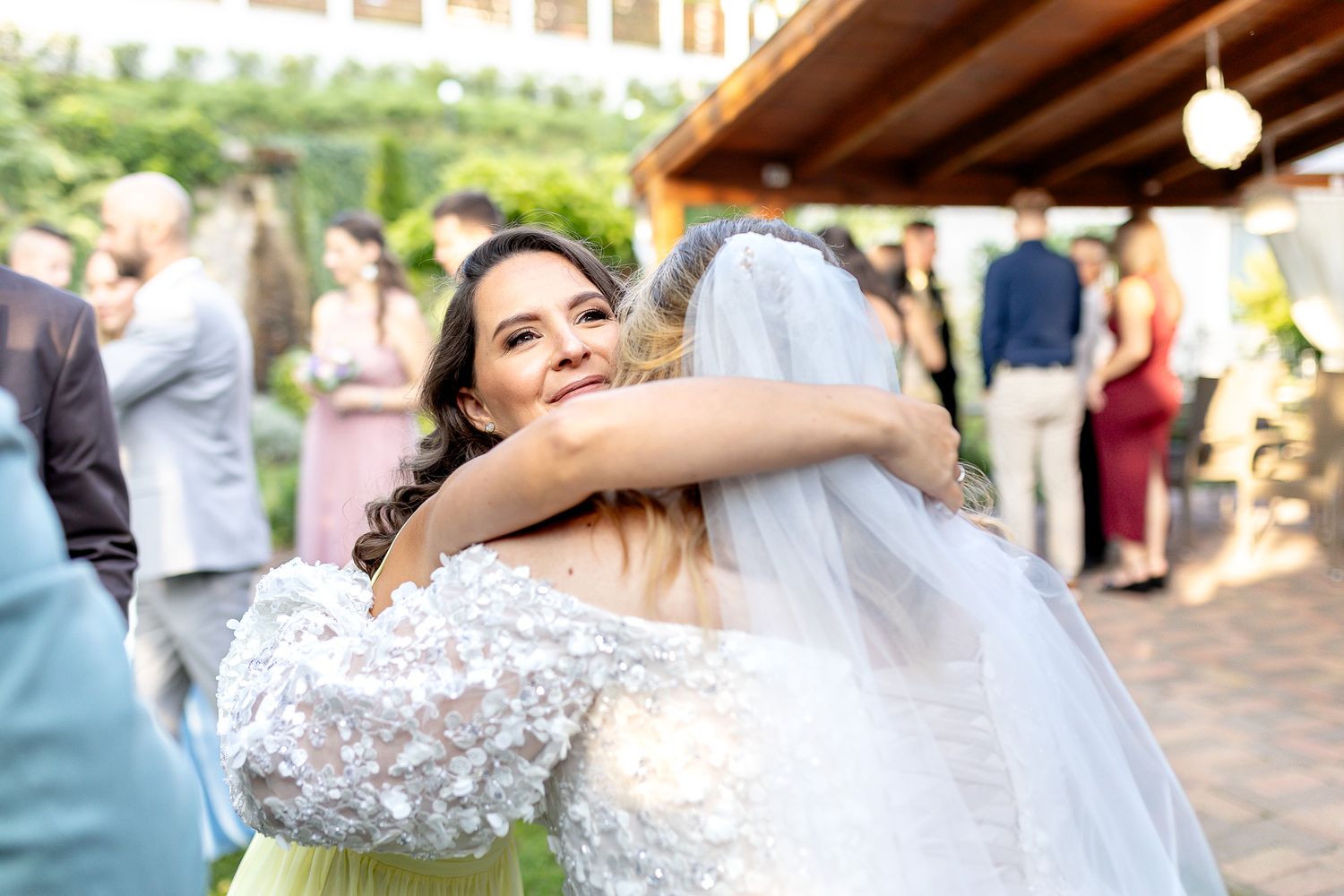 Newlywed couple shares their first dance surrounded by guests at an outdoor wedding reception.