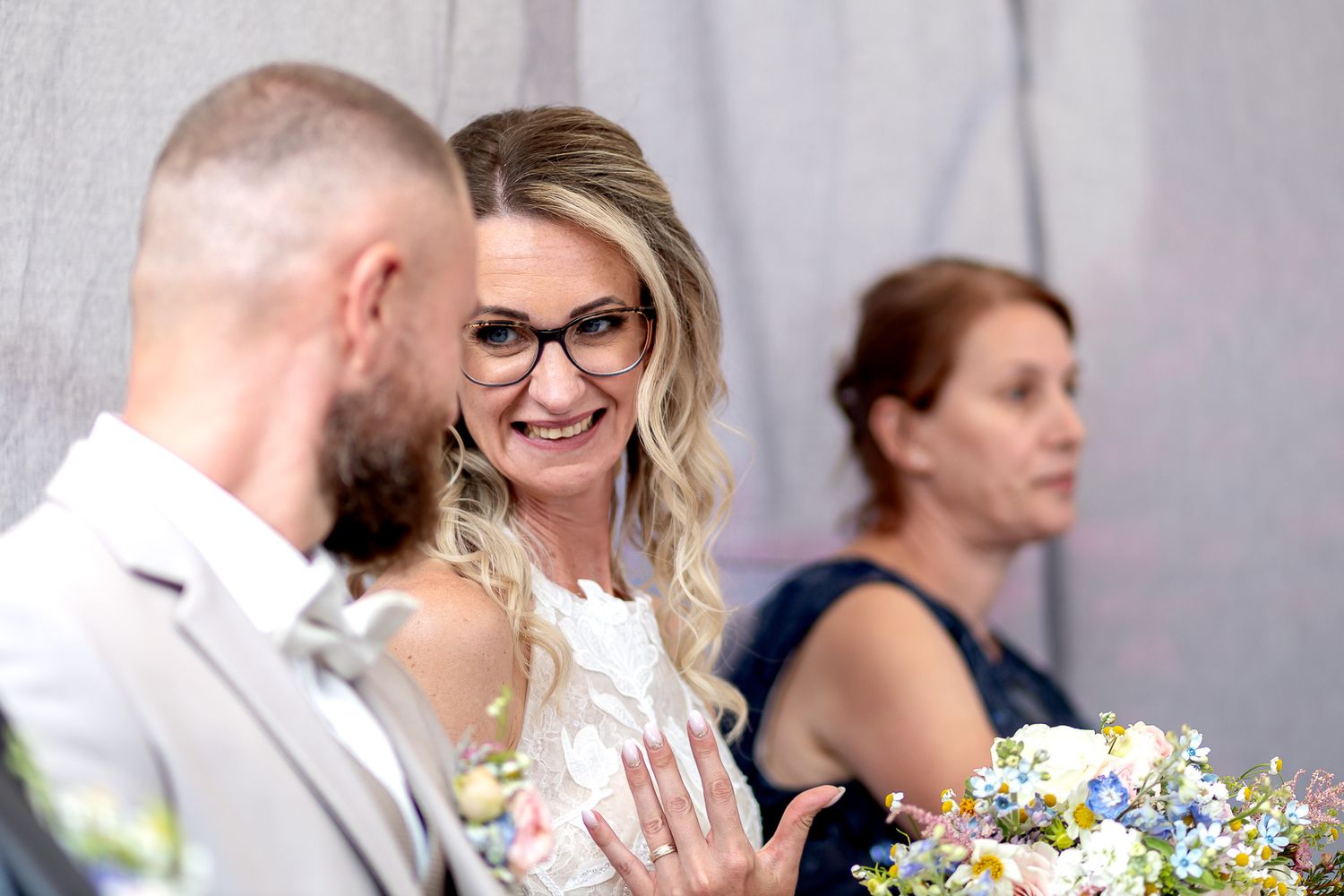 Wedding guests share joyful moments during an outdoor celebration with colorful floral decorations.