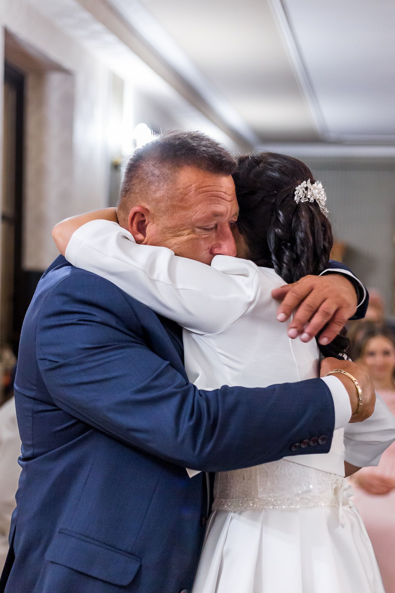 A series of emotional embraces between a couple in formal attire during a wedding ceremony.