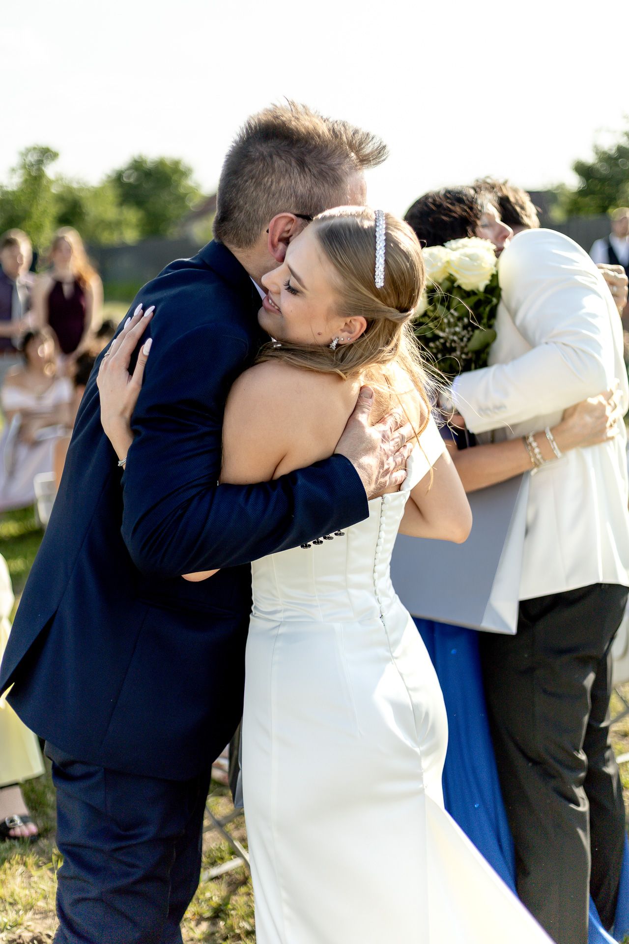 Series of emotional embraces between wedding guests during outdoor celebration.
