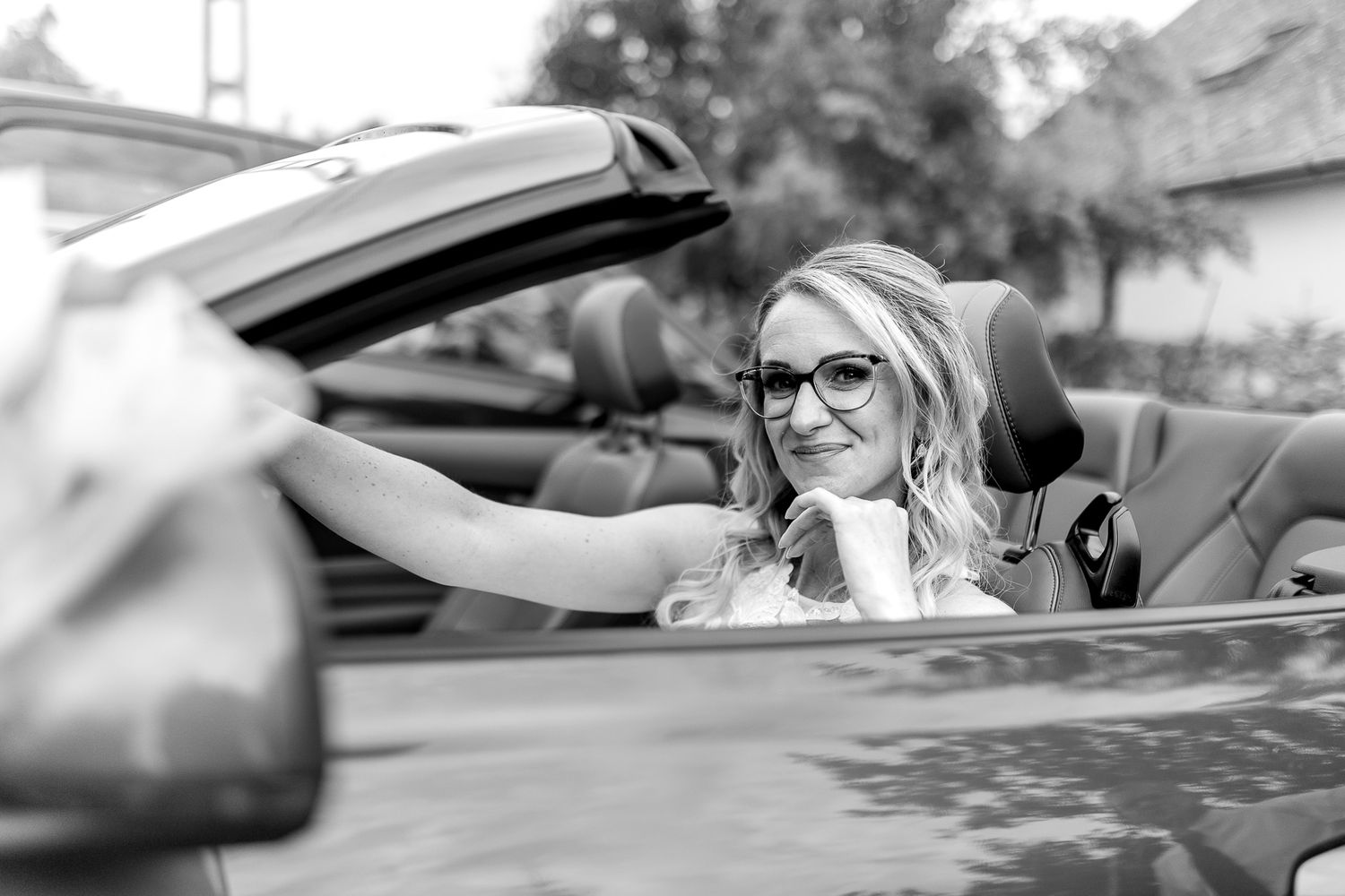 A series of black and white photographs showing different angles of a convertible car with people inside.