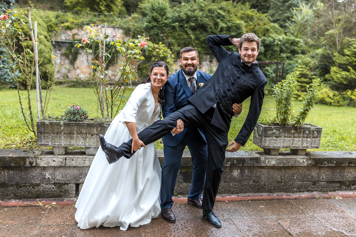 A sequence of wedding photos showing a couple playfully posing in front of a stone wall in a lush garden setting.