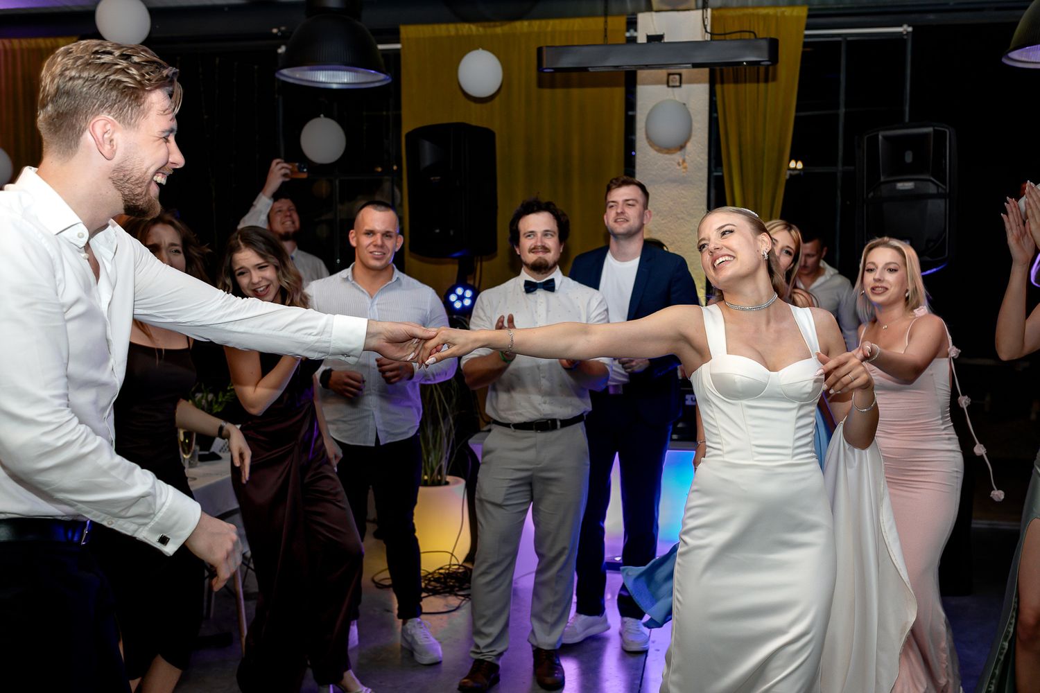 Wedding party members perform synchronized dance moves during reception festivities.