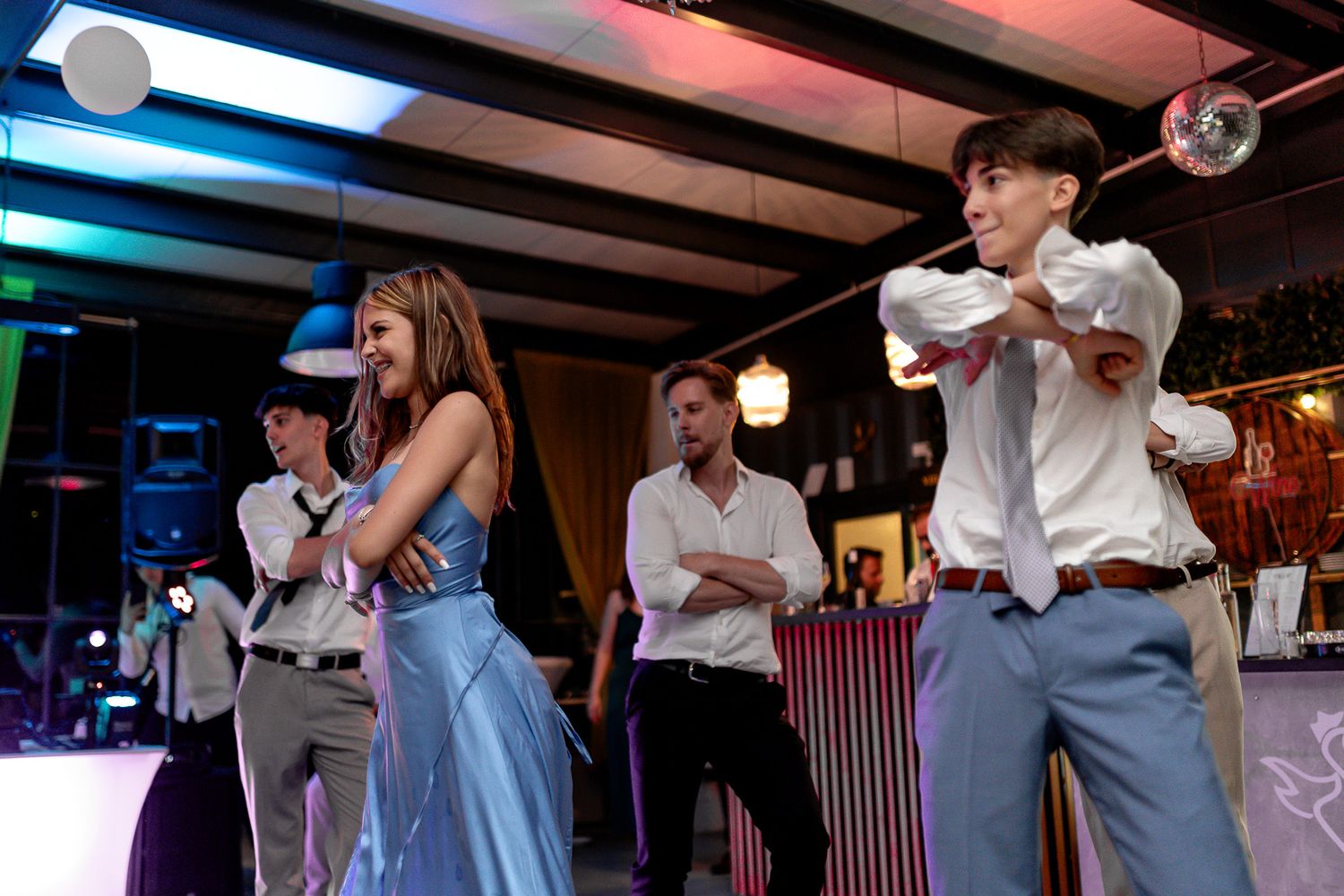 Dancers perform energetic moves on a dance floor during a celebration event.
