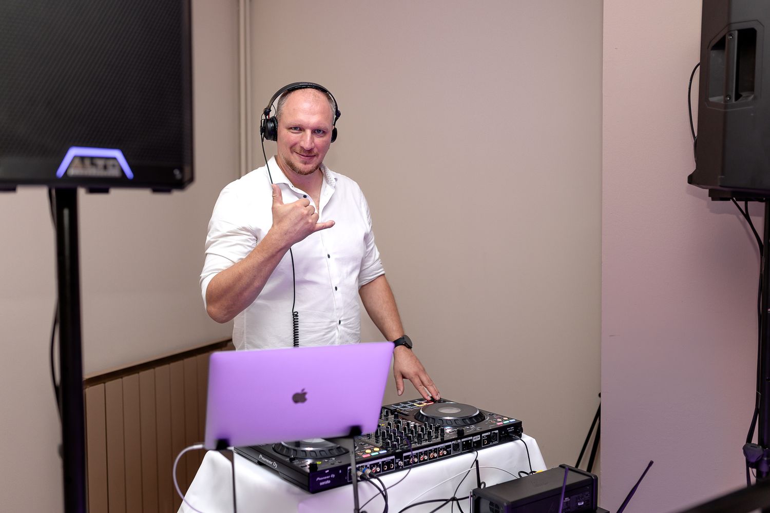 DJ performs at a wedding reception with professional equipment and headphones.