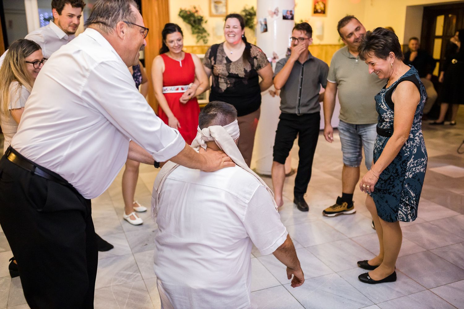 Couples dancing together at a social event in a large indoor venue.