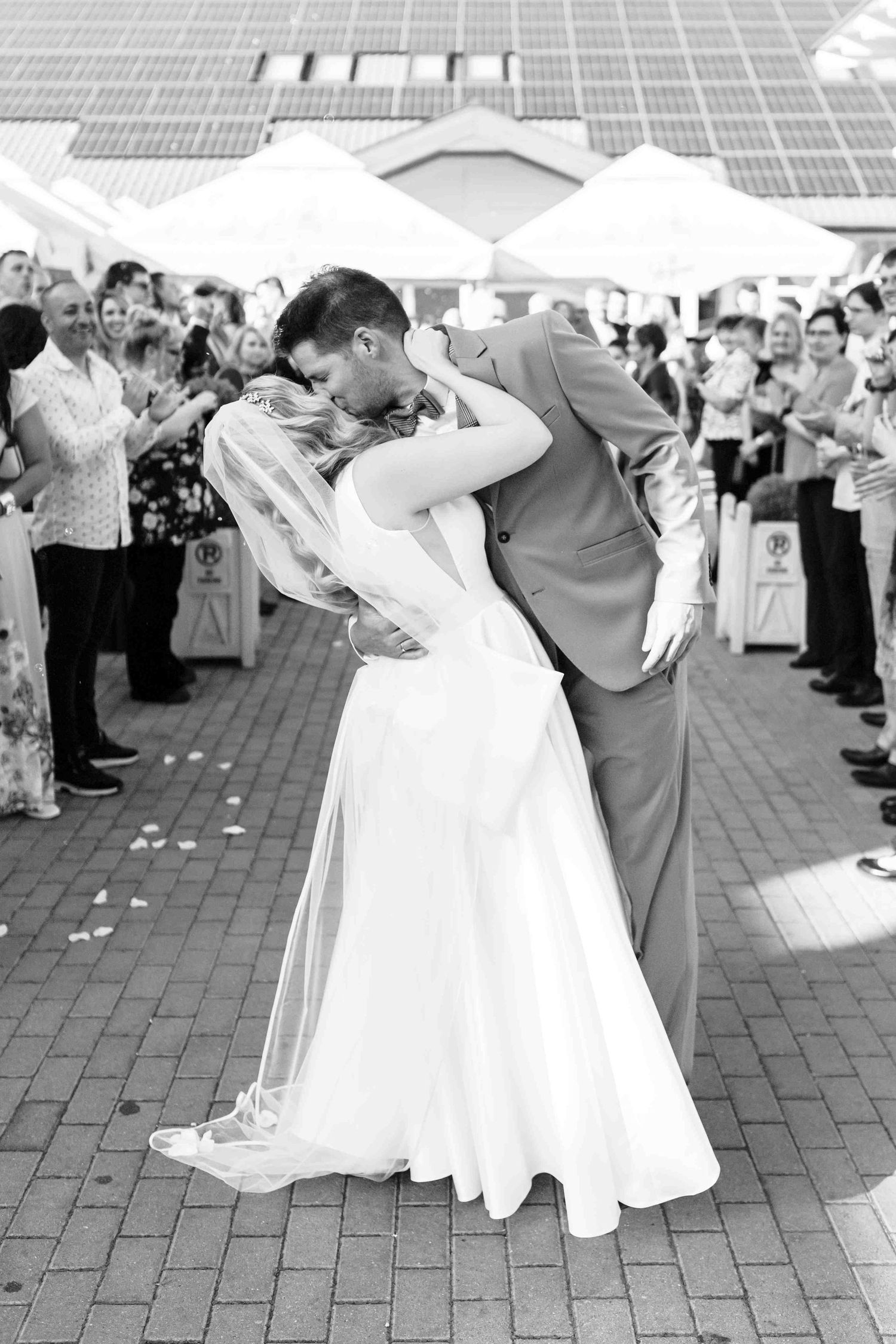 Couples dancing in formal attire at an outdoor event with white dresses and suits creating a festive atmosphere.