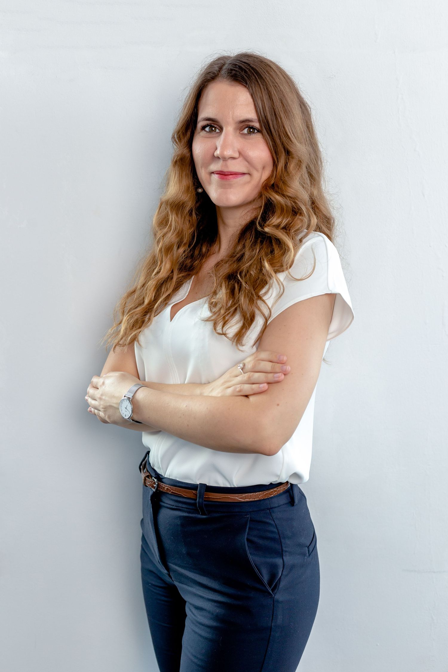 Business casual portraits with white top and navy pants against light background.